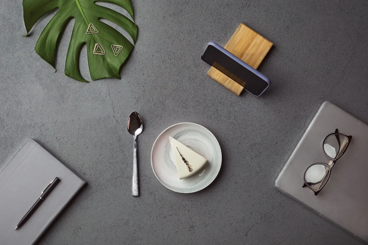 USED_adjustment_minimal-view-flat-lay-cheesecake-business-accessories-grey-workplace-background-with-tropical-leaf+copy.webp