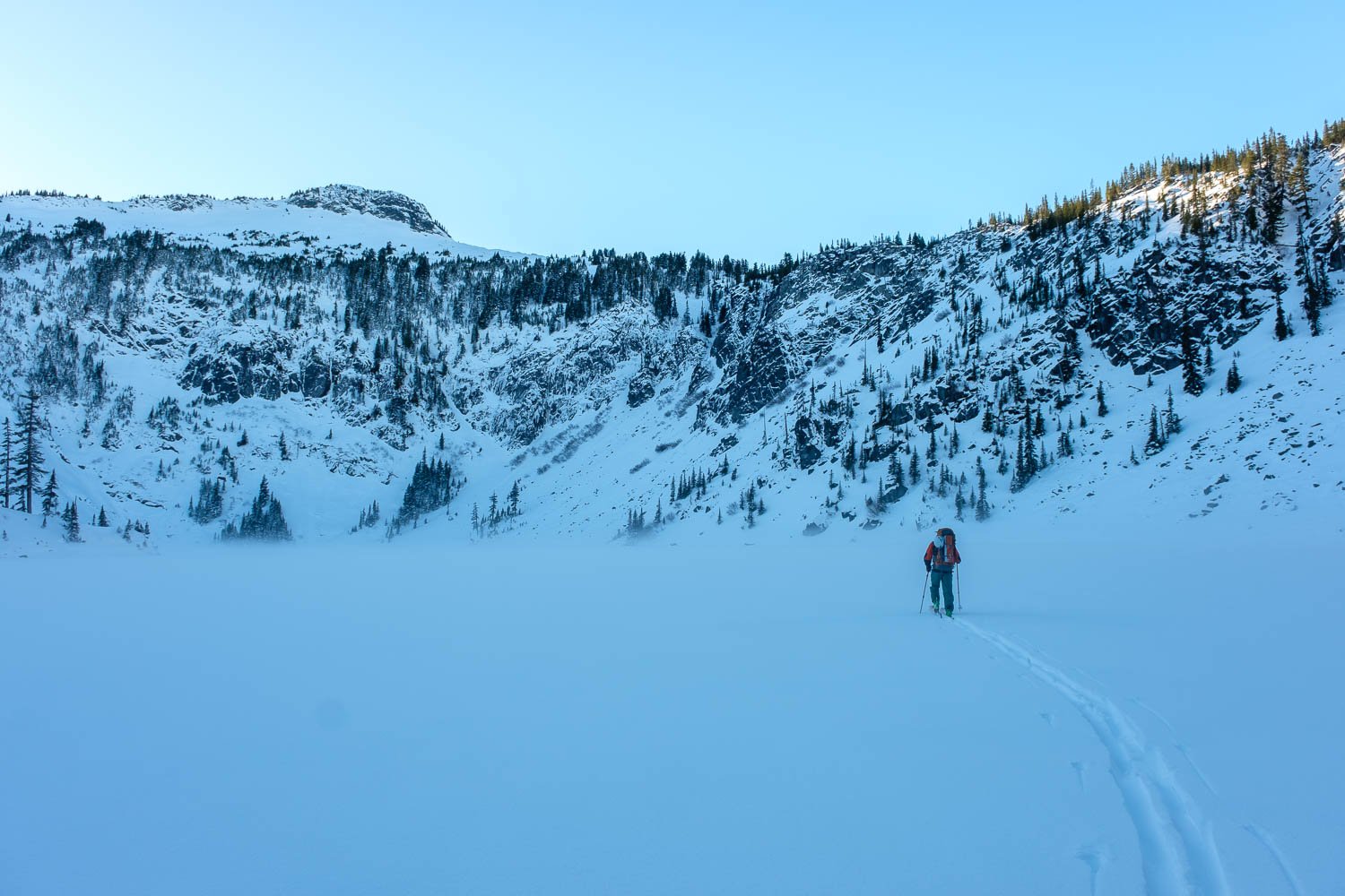  Matt crossing the frigid Upper Wildcat Lake in a temperature inversion. Mount Caroline above. 