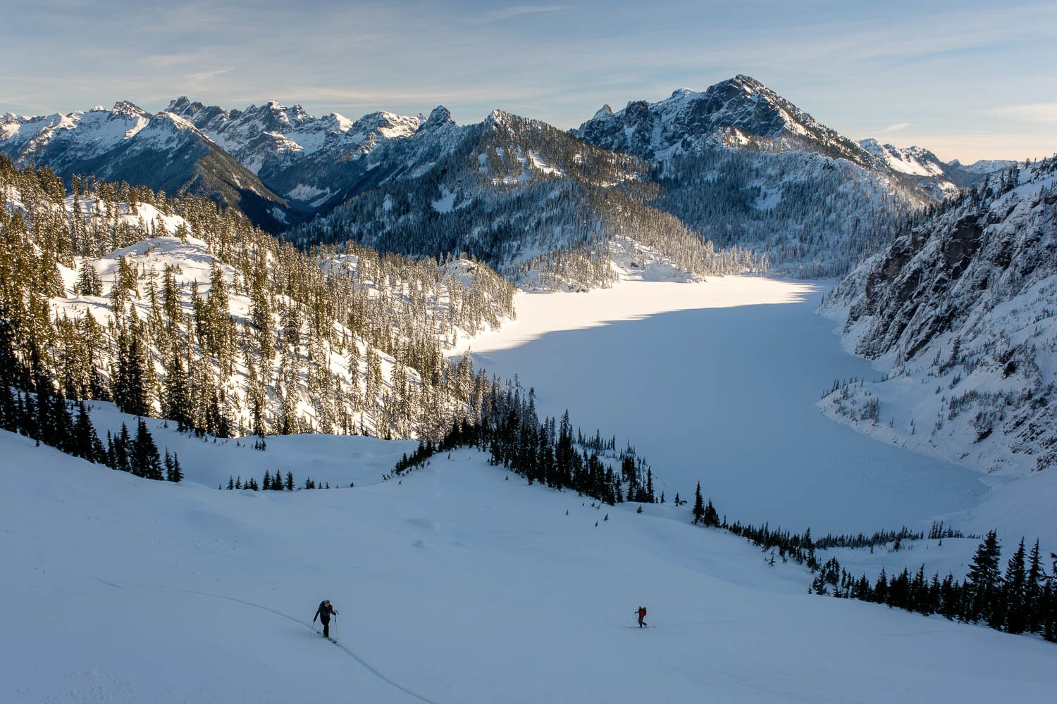  Two skiers above Snow Lake on an adventurous two day traverse of a remote part of the Alpine Lakes Wilderness in December. 