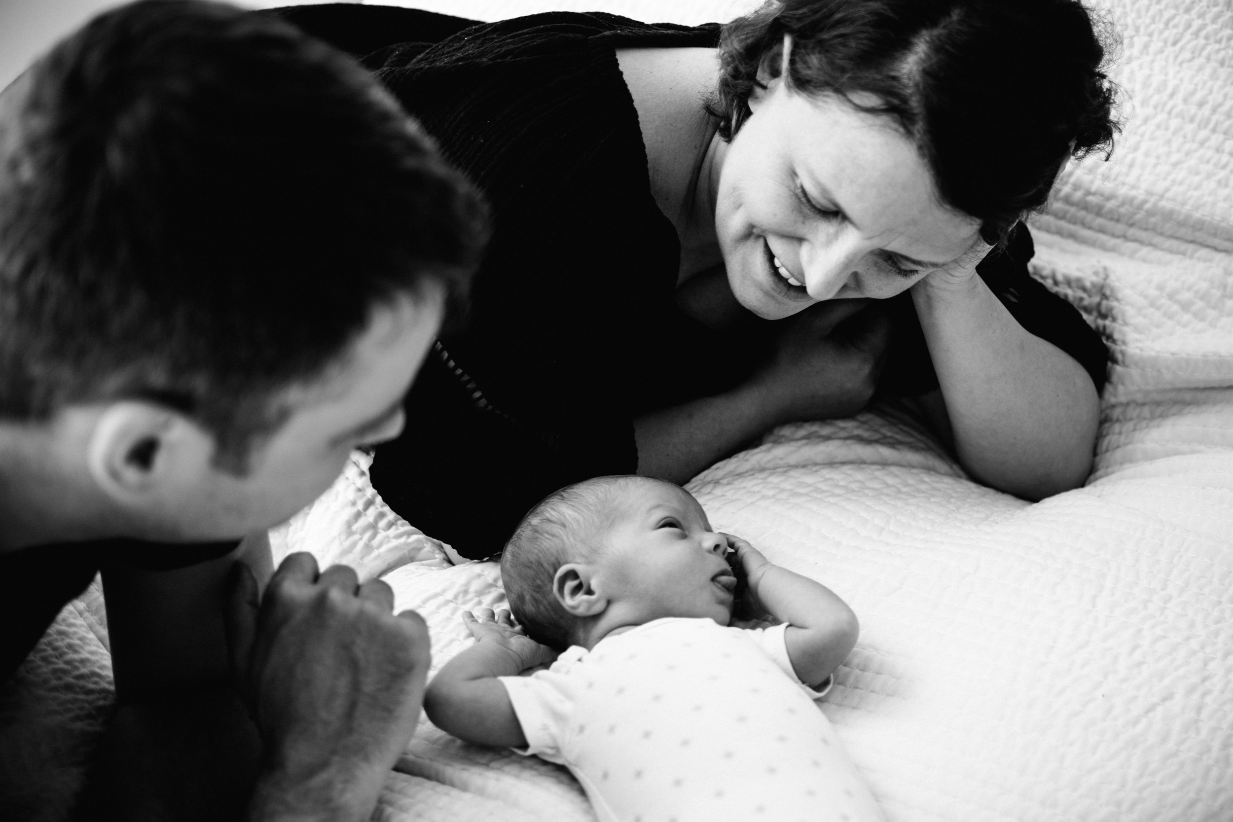 photo-noir-et-blanc-dun-nouveau-ne-et-ses-parents-sur-un-lit_photographe-lifestyle-famille-montreal-7.jpg