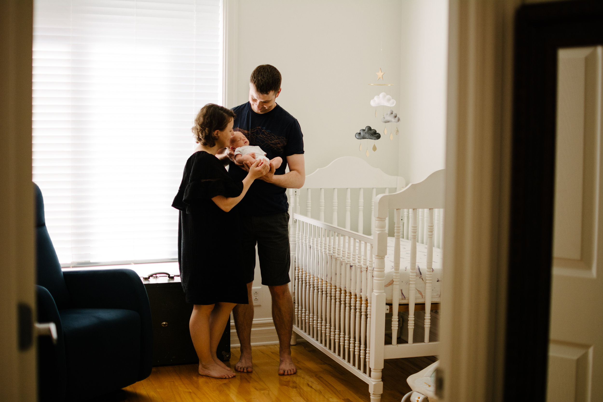 photo-de-parents-et-leur-nouveau-ne-dans-la-chambre-de-bebe_photographe-lifestyle-famille-montreal.jpg