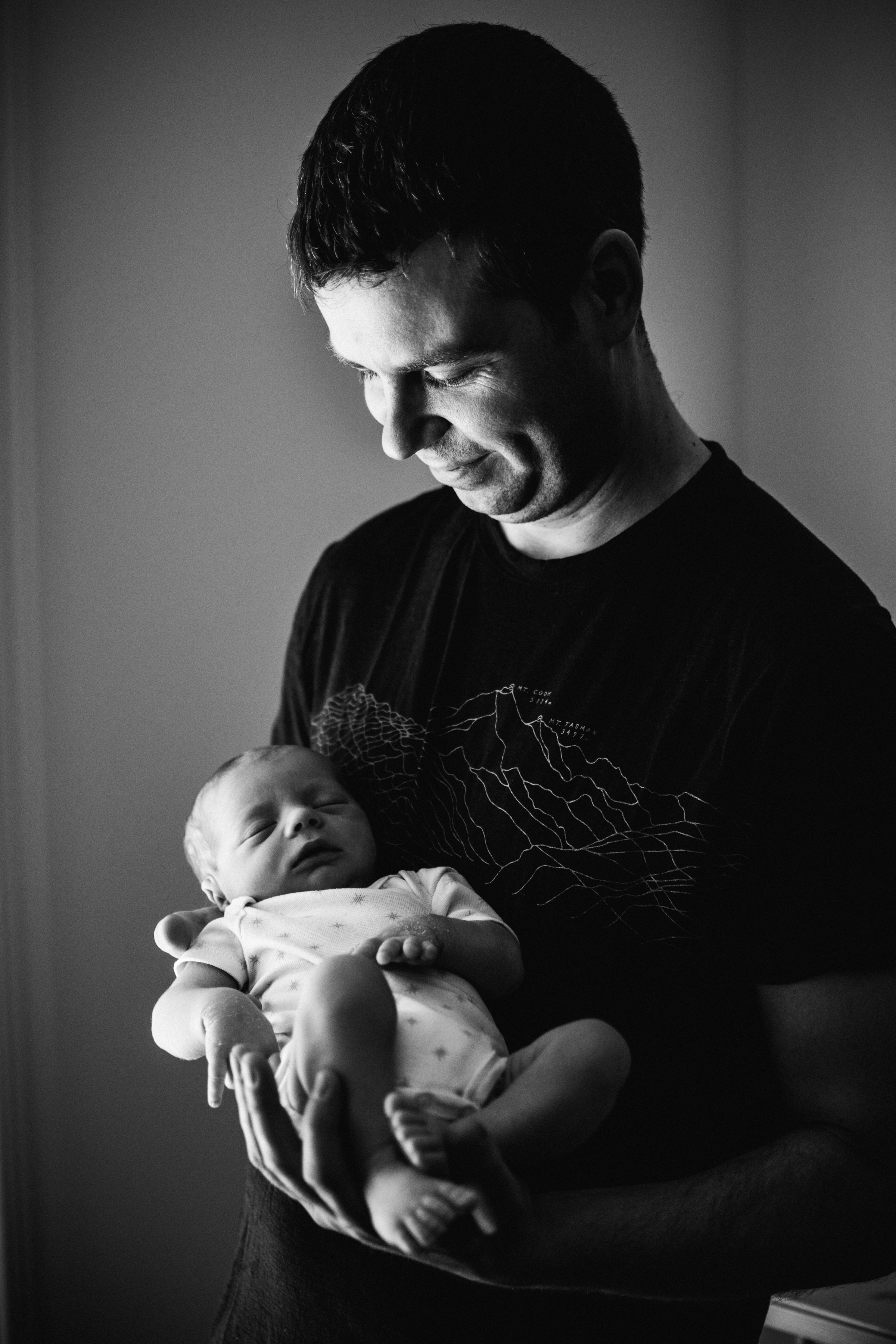 photo-d-un-papa-tenant-son-nouveau-ne-endormi_photographe-lifestyle-famille-montreal-4.jpg