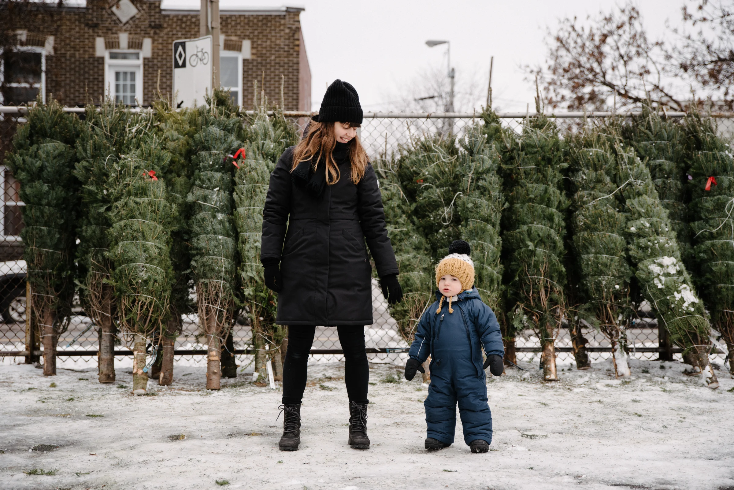 photo-d-un-bambin-de-sa-mere-devant-une-rangee-de-sapins-de-noel-enveloppes-photographe-lifestyle-de-famille-a-montreal-063.jpg