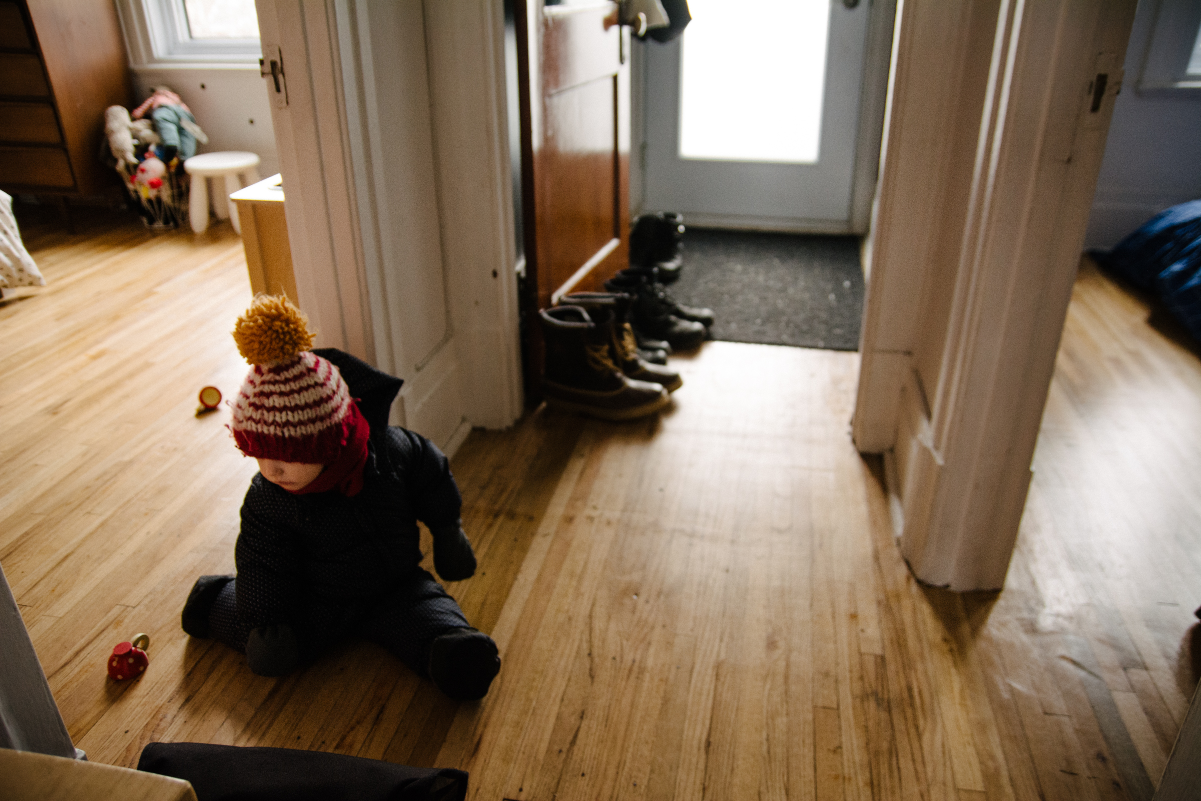 photo-d-un-enfant-dans-son-habit-de-neige-assis-dans-lentree-photographe-famille-lifestyle-a-montreal-118.jpg