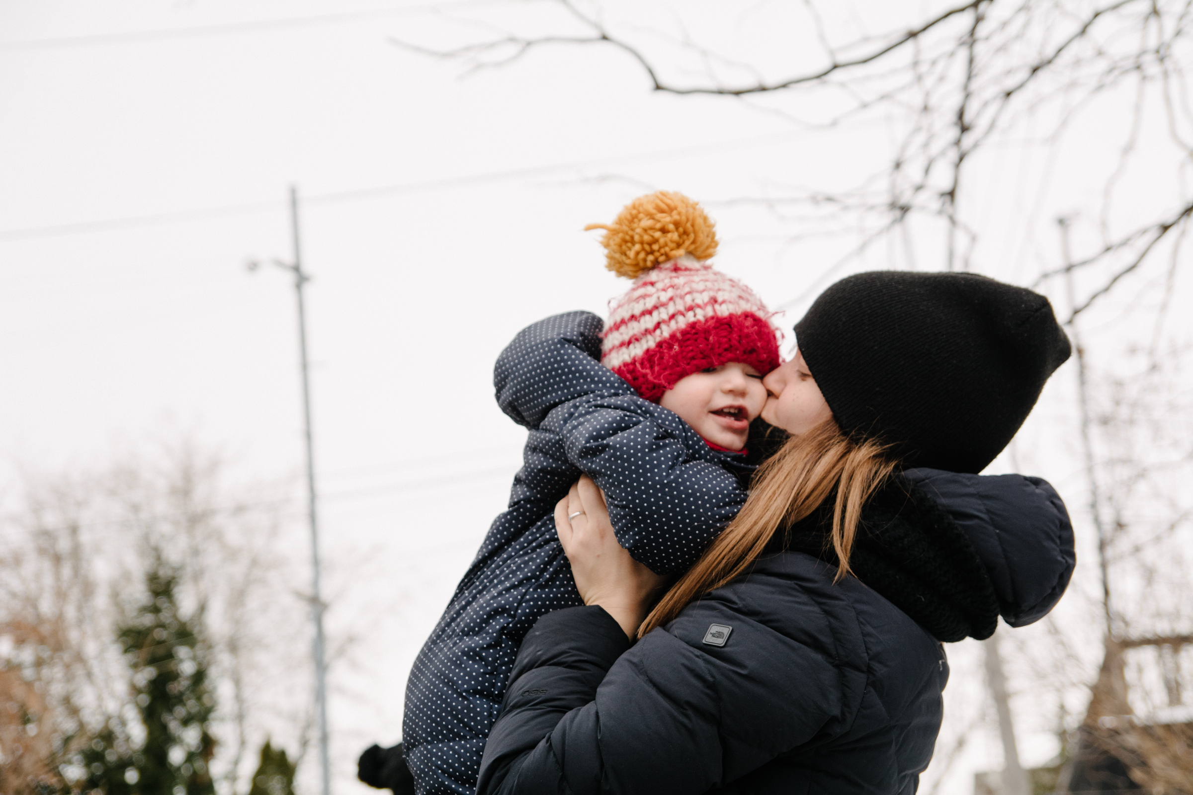 photo-dune-maman-qui-embrasse-son-bebe-emmitoufle-dans-leurs-habits-de-neige-l-hiver-photographe-famille-lifestyle-a-montreal-150.jpg