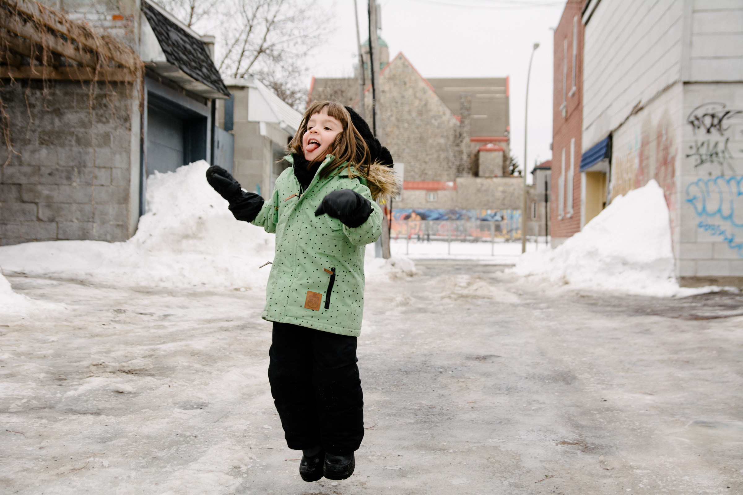 photo-d-un-enfant-qui-saute-sur-la-glace-dans-une-ruelle-de-rosemont-l-hiver-photographe-famille-lifestyle-a-montreal-199.jpg