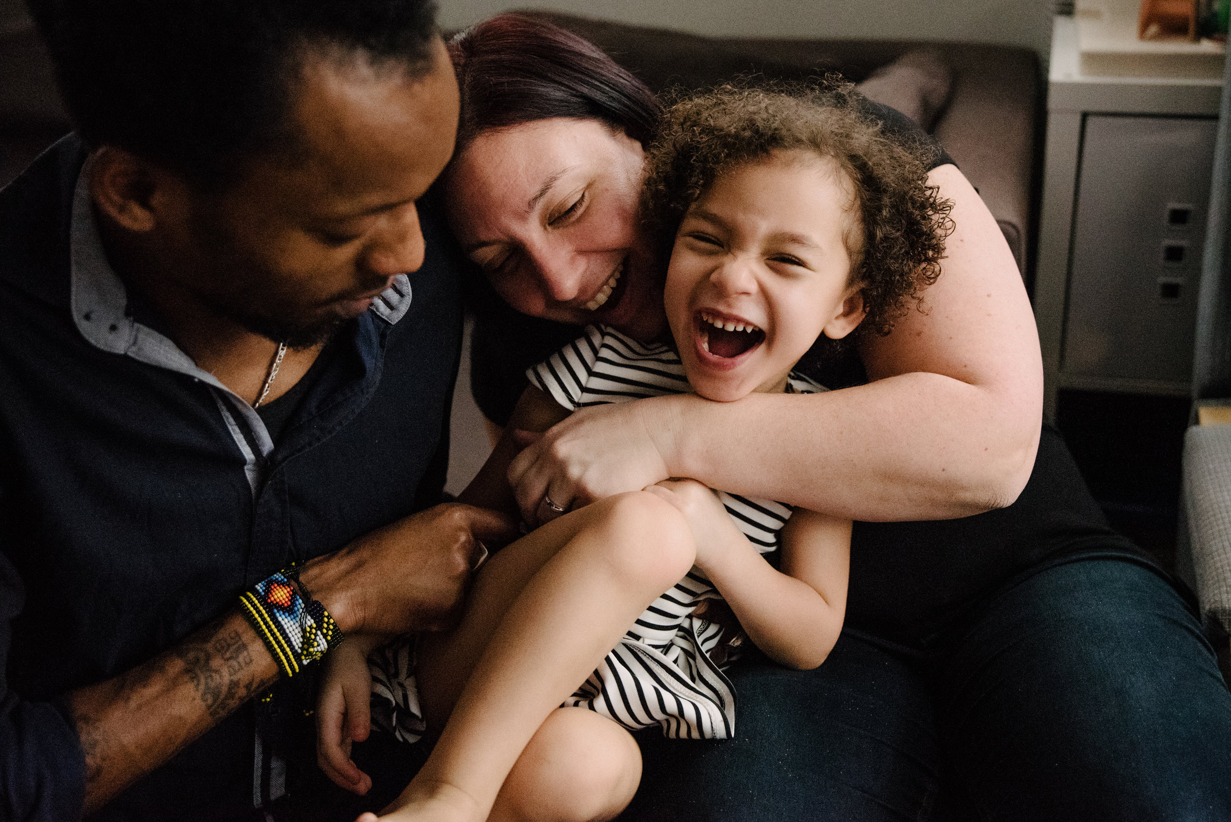 photo-d-une-fillette-et-ses-parents-qui-rigolent-sur-le-divan-photographe-de-famille-a-montreal-marianne-charland-725.jpg