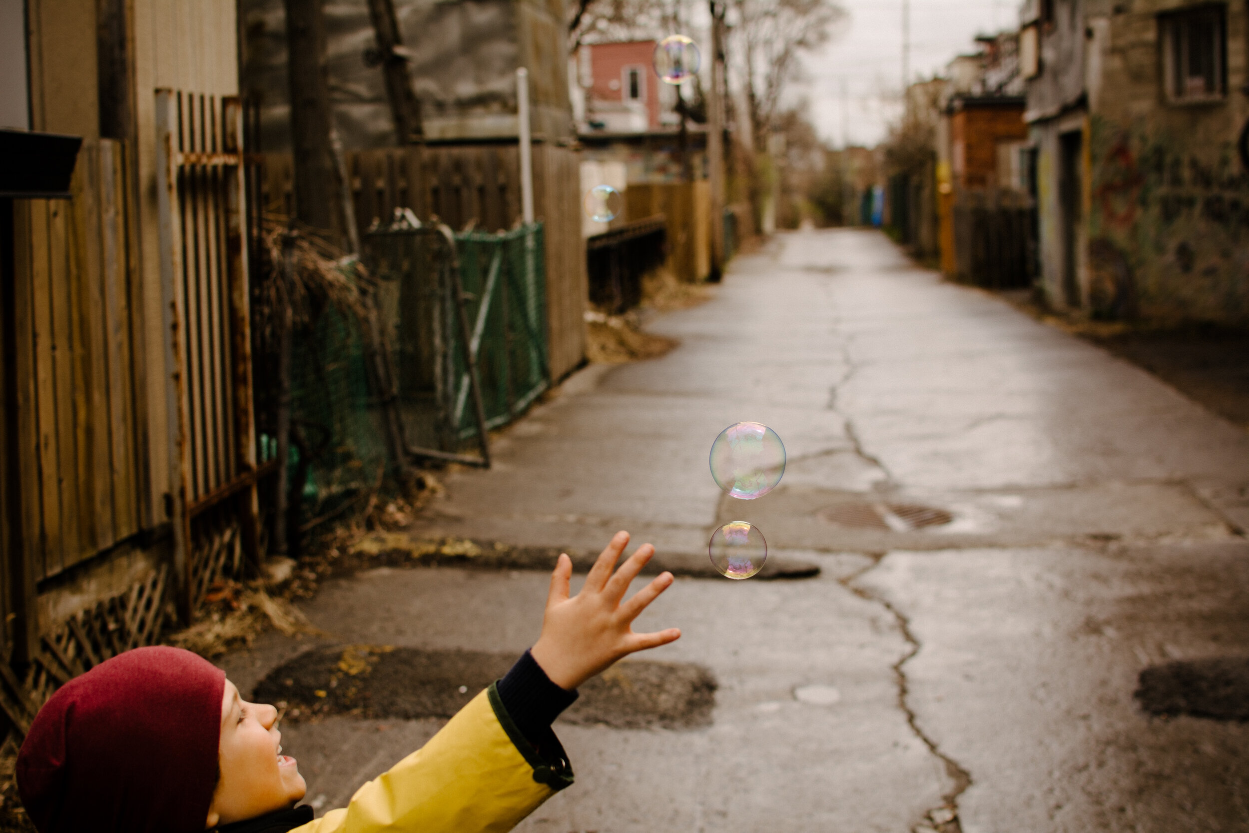 20200501photo-enfant-qui-fait-des-bulles-dans-une-ruelle-montrealaise-photographe-documentaire-famille-lifestyle-a-montreal-006.jpg