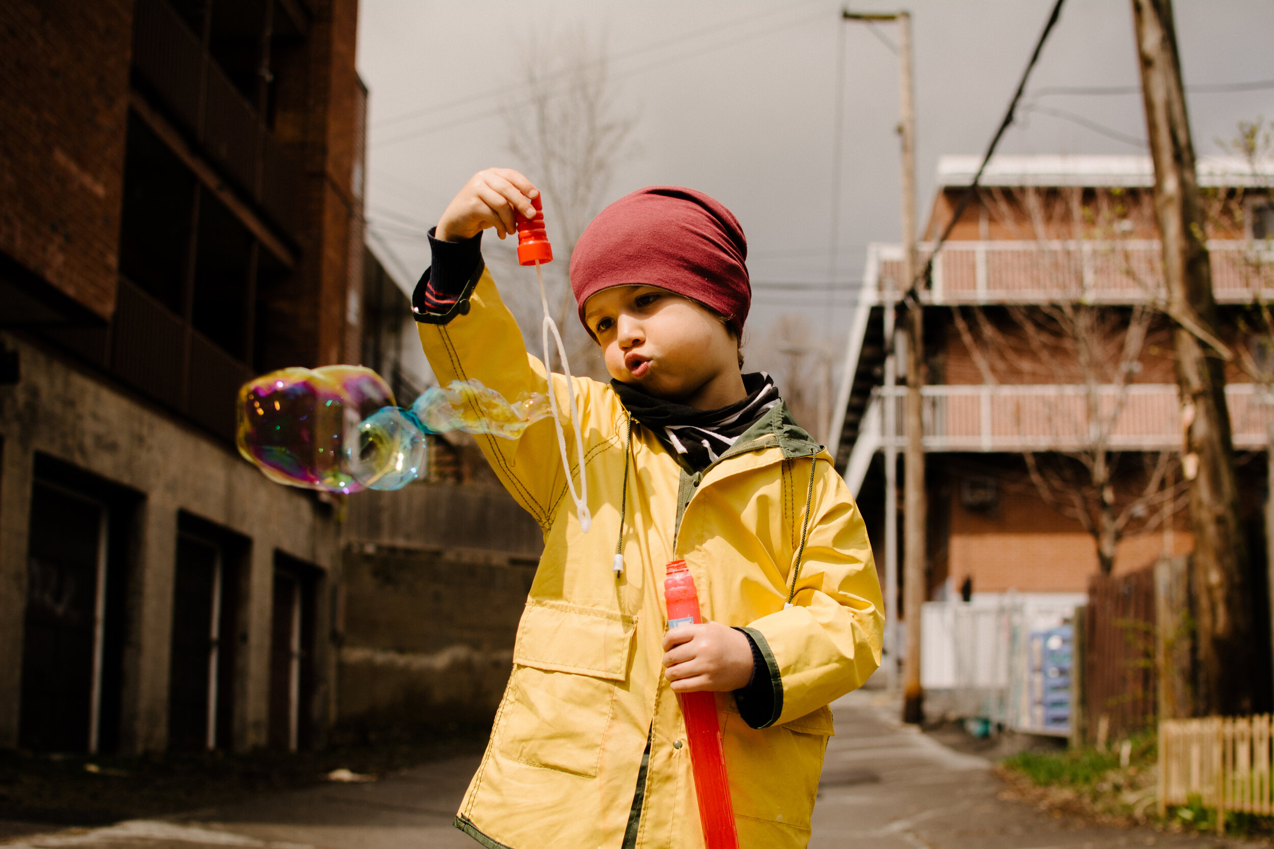 20200501photo-enfant-qui-fait-des-bulles-dans-une-ruelle-montrealaise-photographe-documentaire-famille-lifestyle-a-montreal-004.jpg