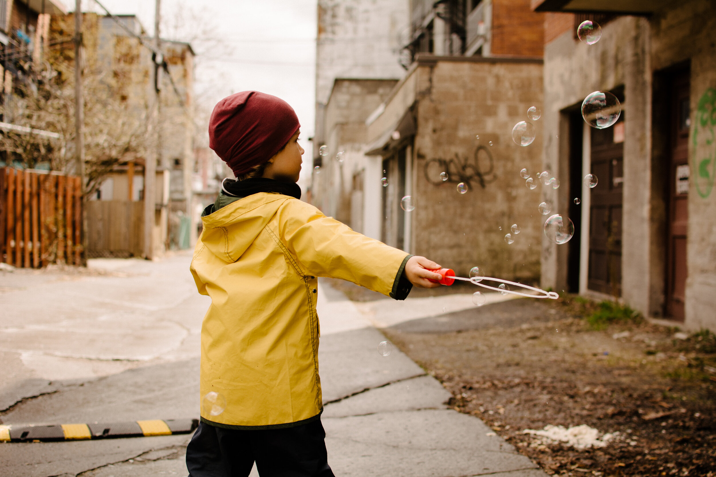 20200501photo-enfant-qui-fait-des-bulles-dans-une-ruelle-montrealaise-photographe-documentaire-famille-lifestyle-a-montreal-002.jpg