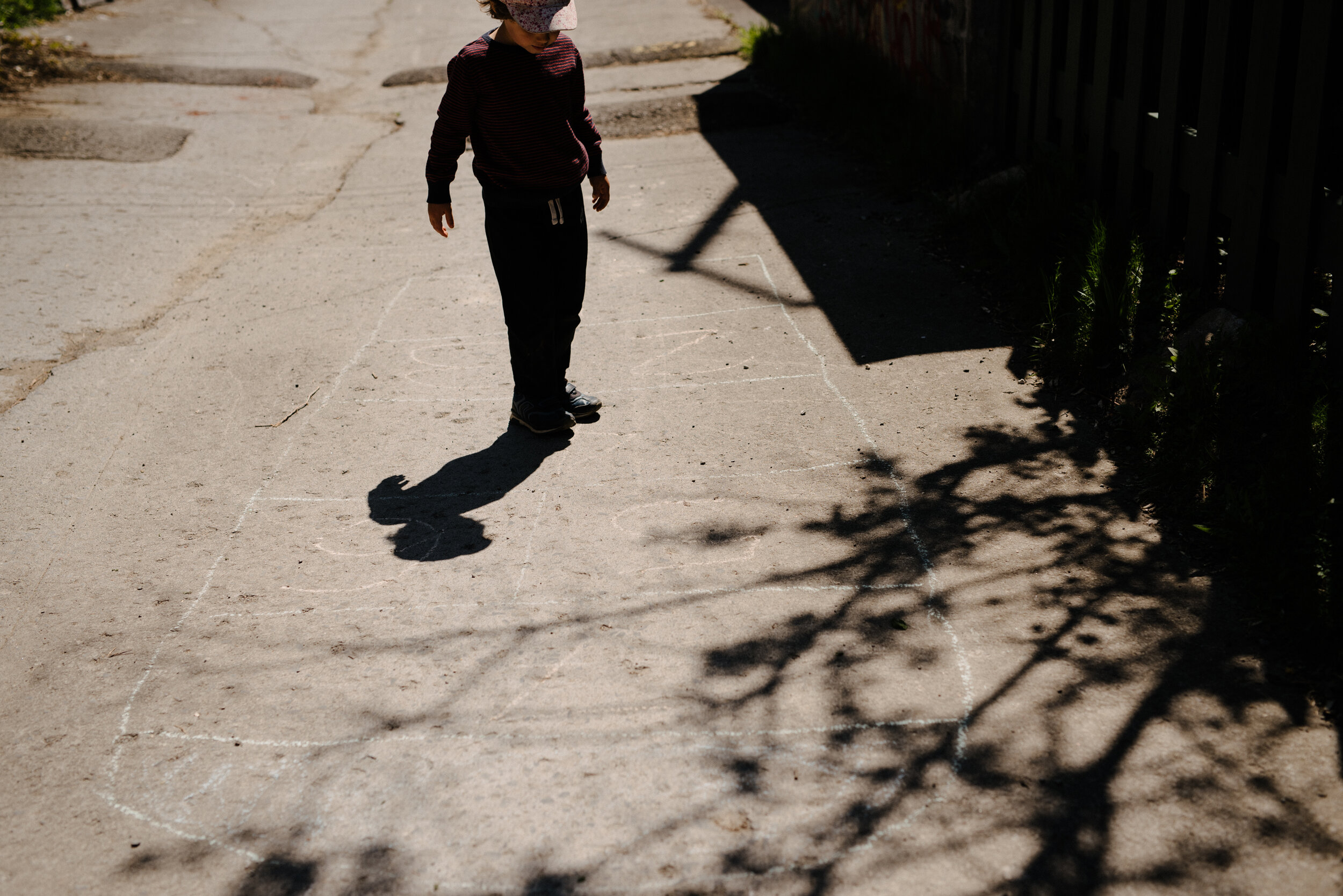 20200520_photo-enfant-qui-joue-a-la-marelle-avec-son-ombre-dans-une-ruelle-photographe-lifestyle-documentaire-de-famille-a-montreal-001.jpg