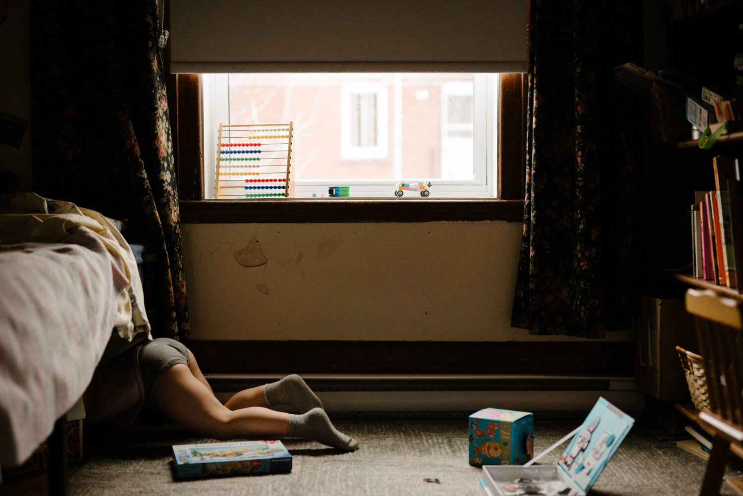 photo-seance-day-in-the-life-enfant-jeu-cache-sous-un-lit-marianne-charland-photographe-de-famille-a-montreal-1.jpg