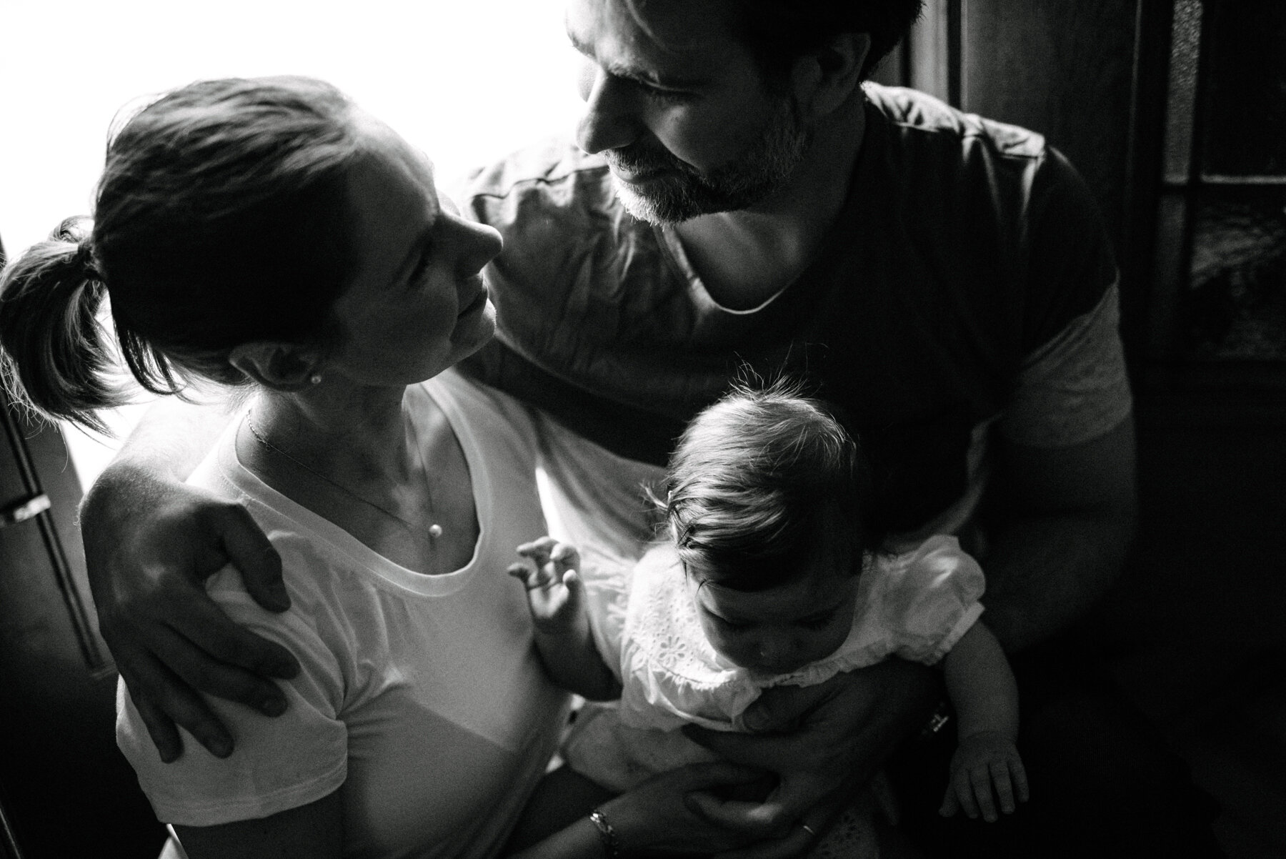 031photo-noir-et-blanc-parents-qui-se-regardent-amoureusement-en-tenant-leur-fillette-photographe-de-famille-a-montreal-marianne-charland-807.jpg