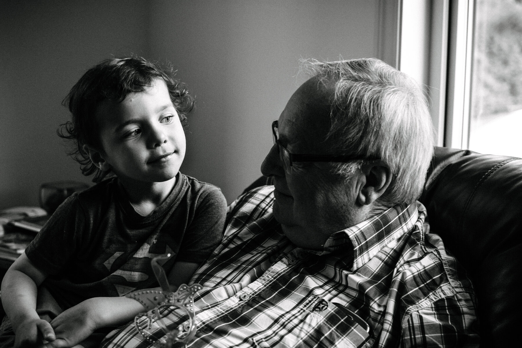 062photo-noir-et-blanc-garcon-qui-regarde-son-grand-pere-dans-les-yeux-avec-amour-et-interrogation-photographe-de-famille-a-montreal-marianne-charland-269.jpg