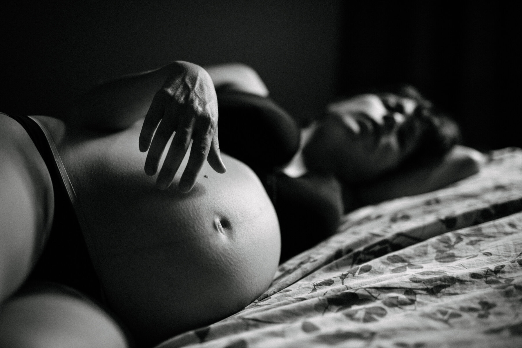 003photo-noir-et-blanc-femme-enceinte-couchee-sur-un-lit-et-touchant-delicatement-son-ventre-photographe-lifestyle-de-maternite-a-montreal-marianne-charland-934.jpg