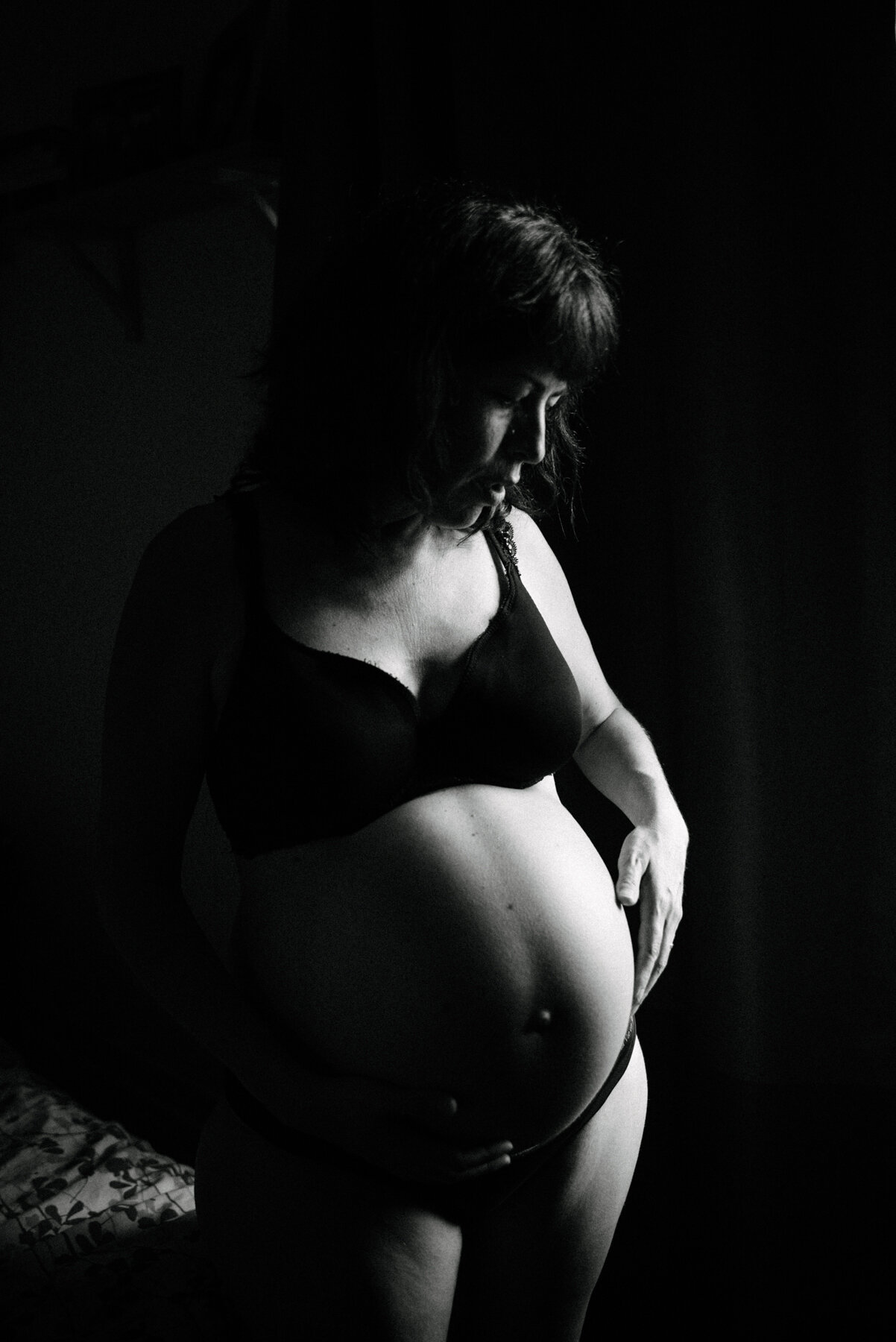 015photo-noir-et-blanc-silhouette-femme-enceinte-debout-touchant-son-ventre-du-bout-des-doigts-photographe-lifestyle-de-maternite-a-montreal-marianne-charland-891.jpg