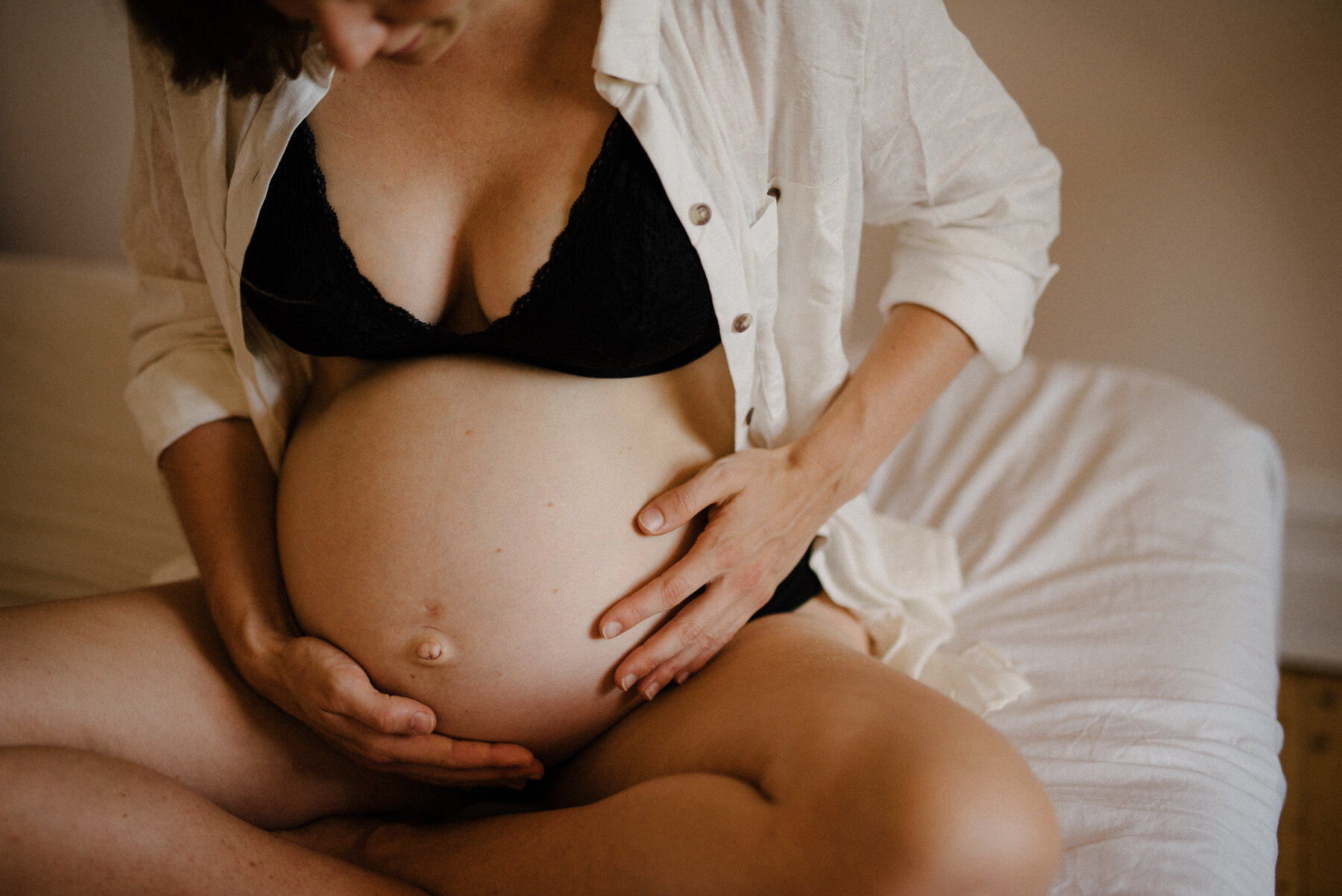 035photo-femme-enceinte-qui-touche-son-ventre-assise-sur-lit-photographe-de-maternite-nouveau-ne-a-montreal-marianne-charland-412.jpg