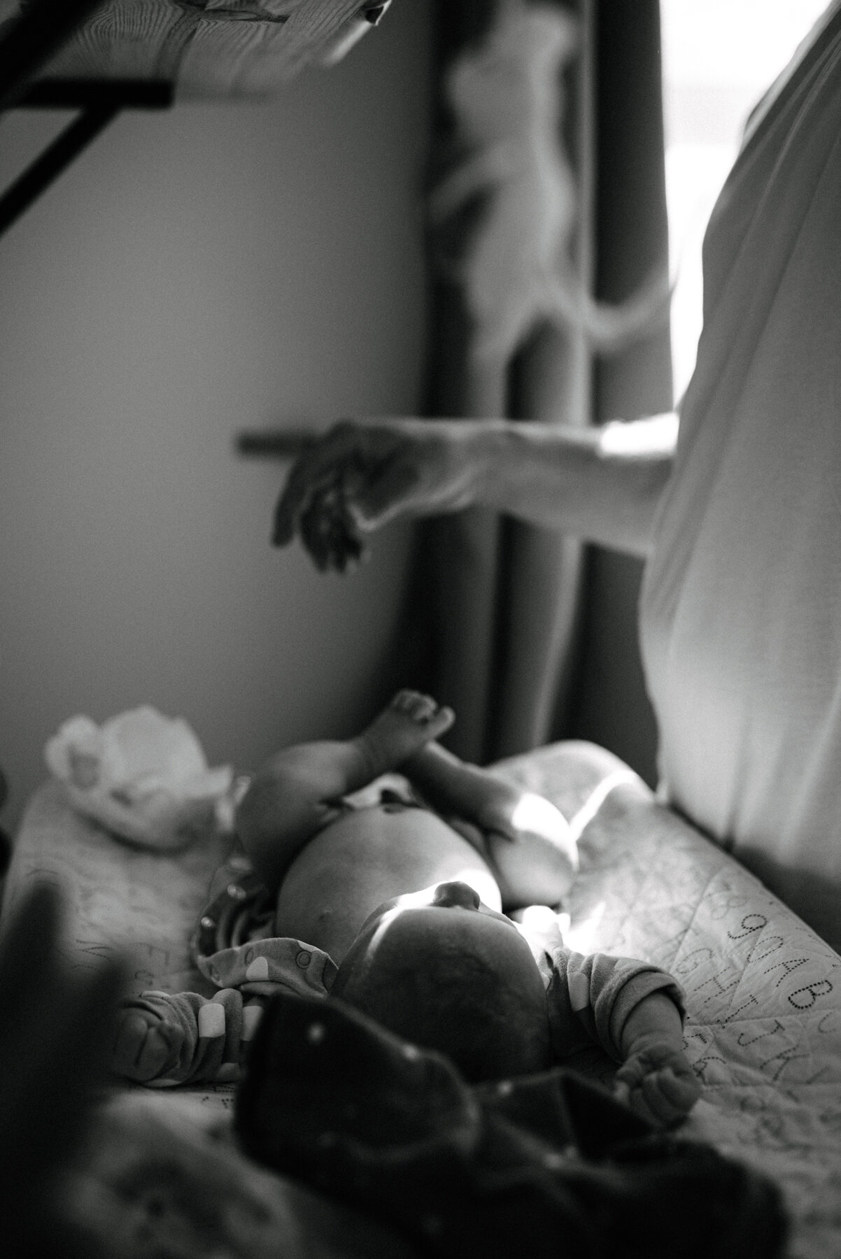 057photo-noir-et-blanc-bebe-sur-table-a-langer-avec-papa-photographe-maternite-nouveau-ne-a-montreal-marianne-charland-015.jpg