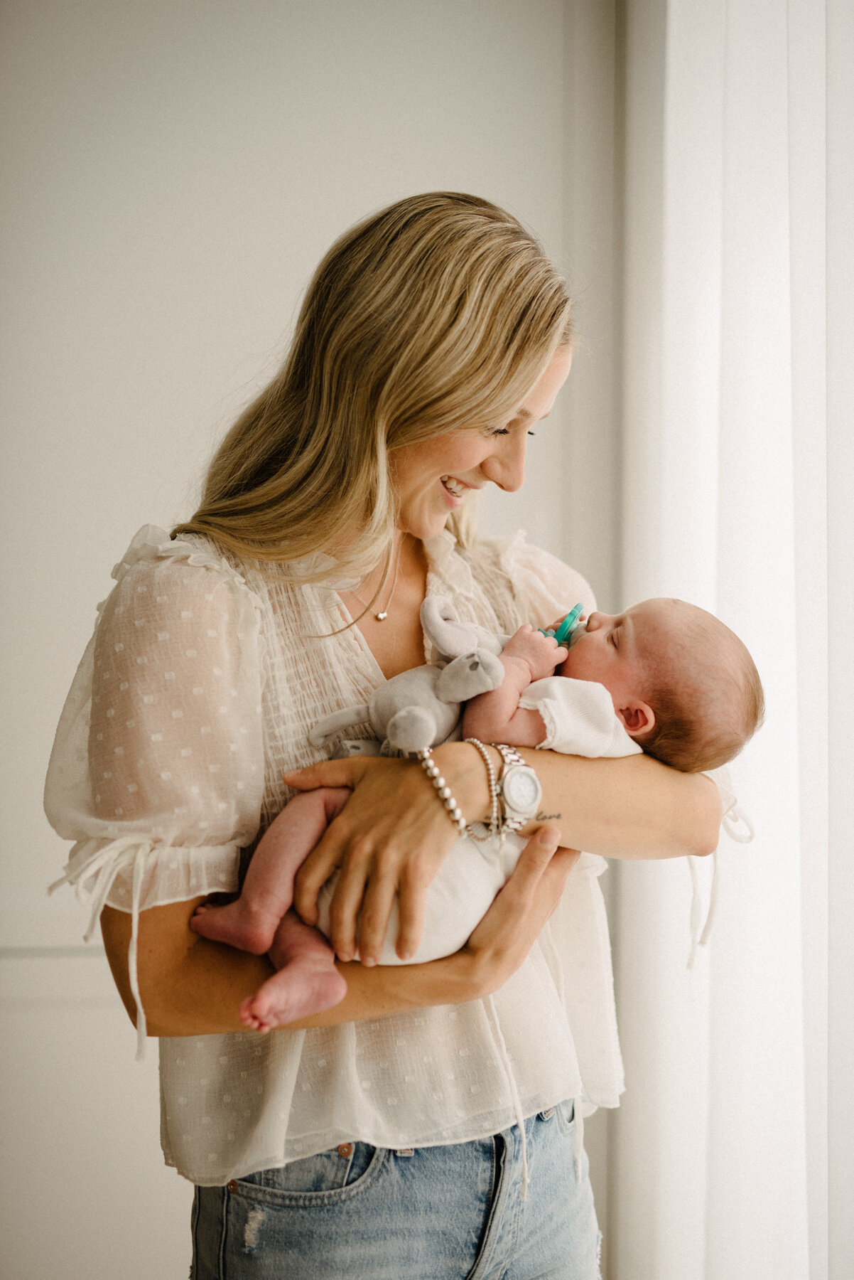 058photo-maman-tout-sourire-tient-bebe-endormi-dans-ses-bras-photographe-maternite-nouveau-ne-a-montreal-marianne-charland-095.jpg