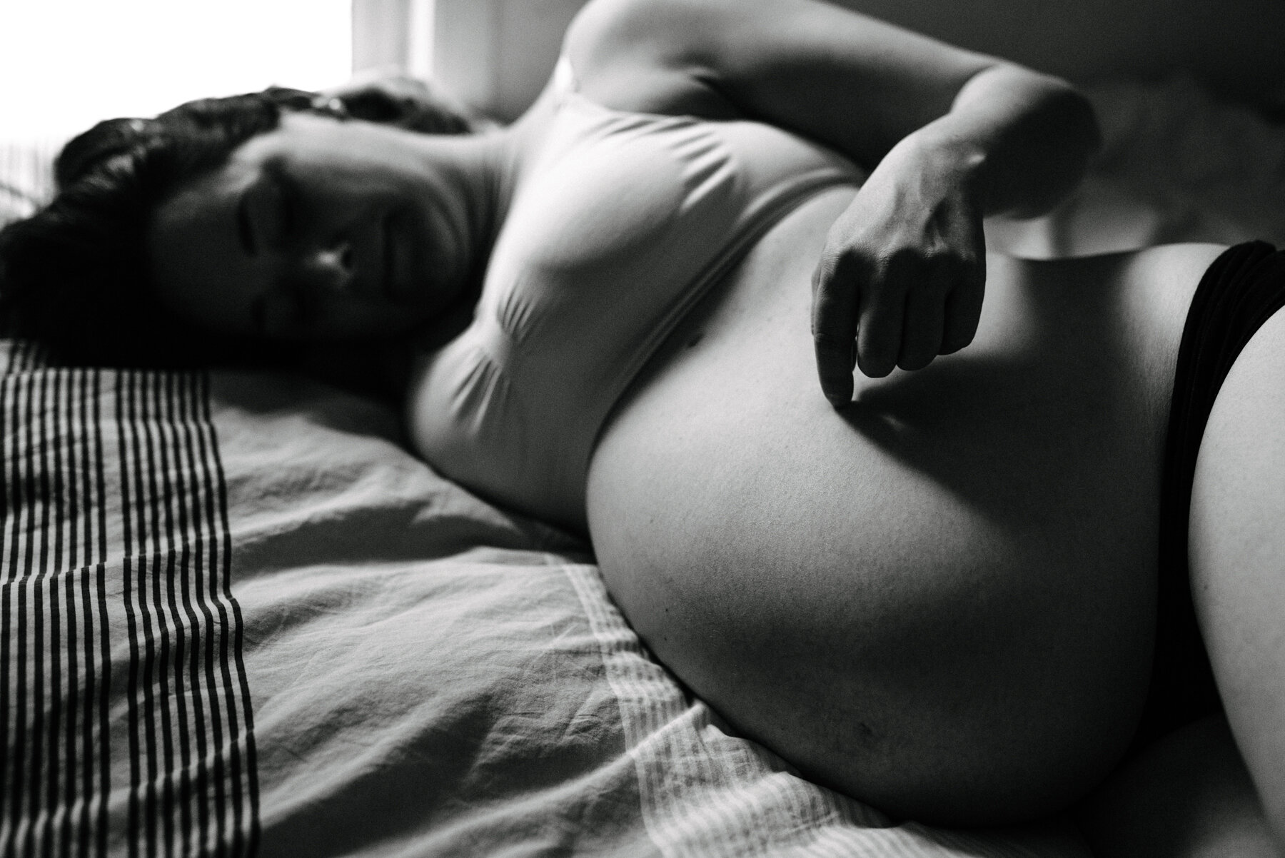 068photo-noir-et-blanc-intime-femme-enceinte-couchee-sur-lit-touchant-son-ventre-photographe-maternite-nouveau-ne-a-montreal-marianne-charland-279.jpg