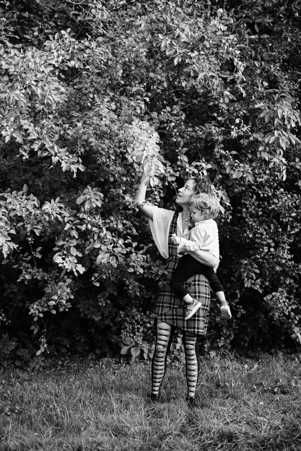 005photo-noir-et-blanc-maman-qui-cueille-des-fruits-avec-son-petit-au-parc-maisonneuve_seance-lifestyle-photographe-de-famille-a-montreal-183.jpg