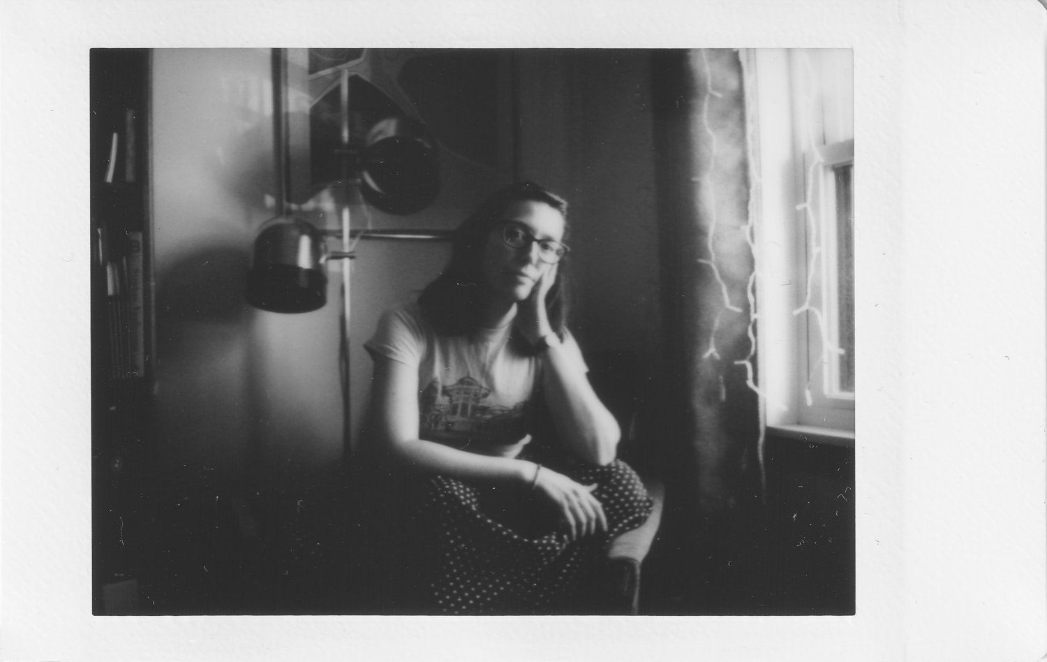 20211214_Instax-2400-1_autoportrait-femme-serieuse-assise-sur-fauteuil-noir-et-blanc-photo-instantanee-photographe-documentaire-de-famille-a-montreal.jpg