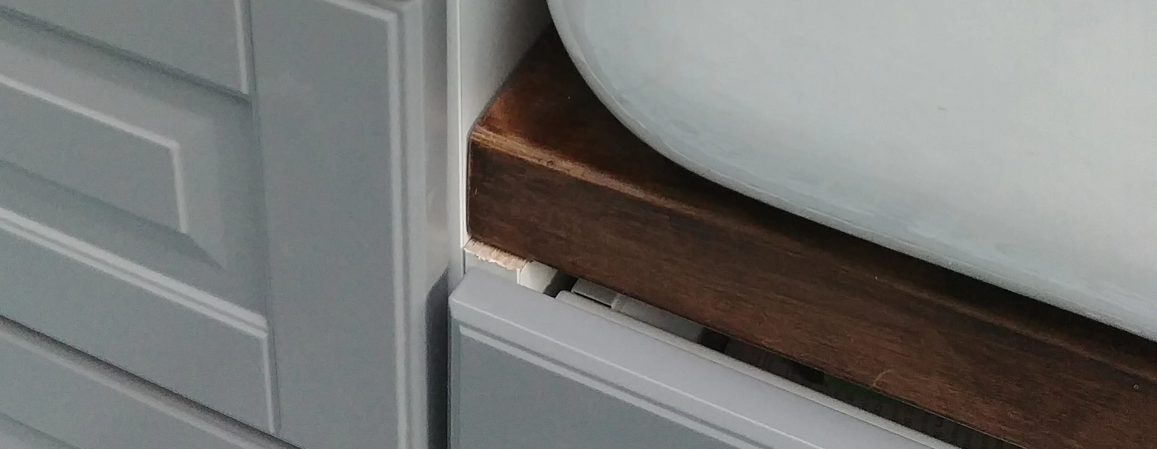 You can see the wooden supporting beam underneath the curved corner of the sink front. 