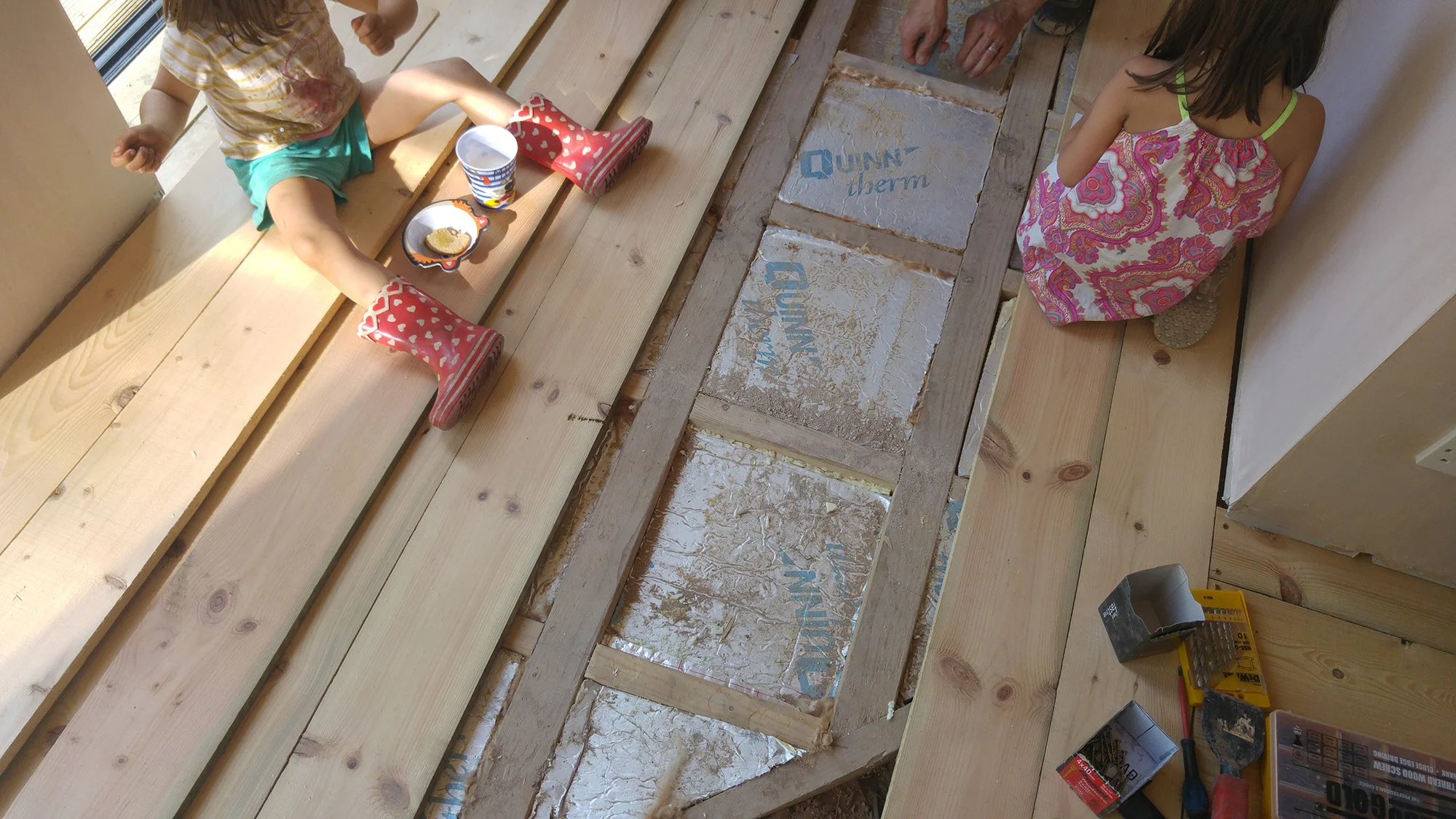 Laying the new (old) boards on top of the insulation board. Kids helping out as always.