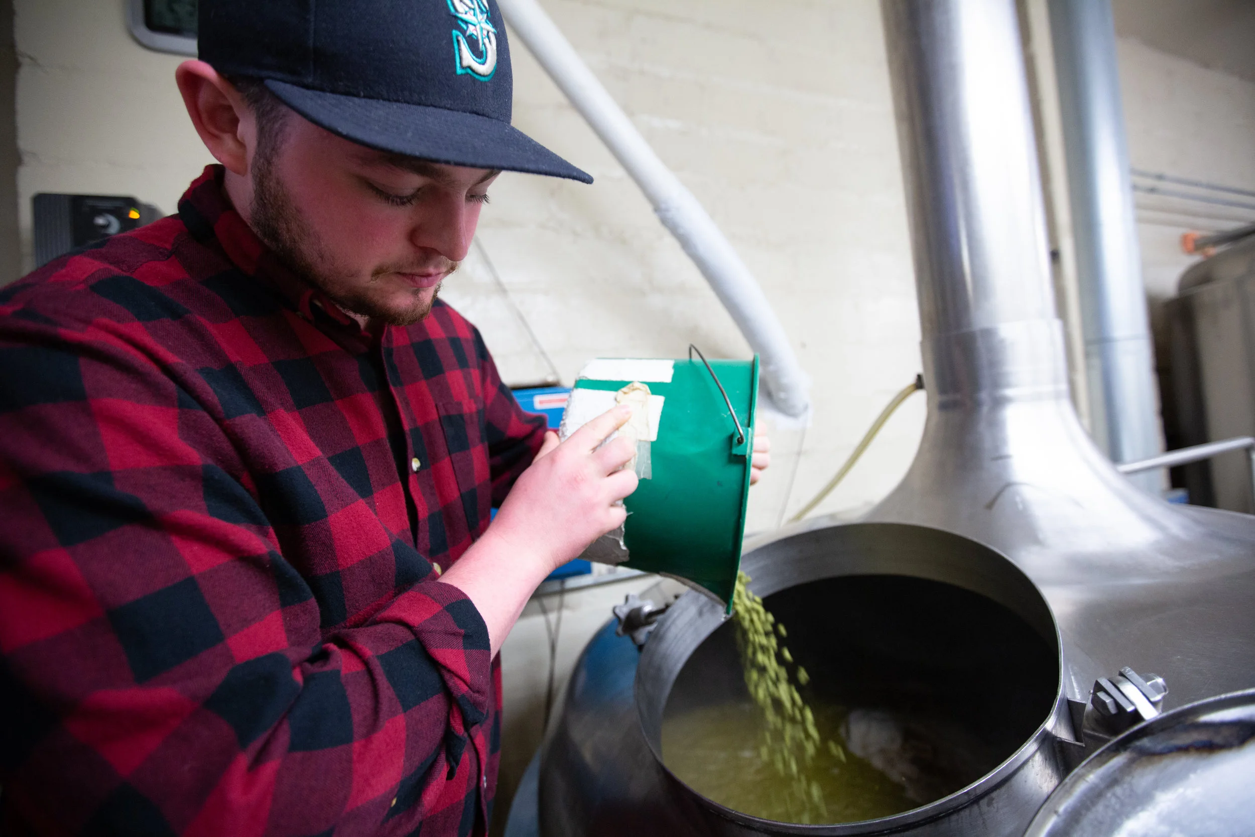 Army Veteran and bartender, Sam Stringer helps pour the hops for the Gratitude IPA.