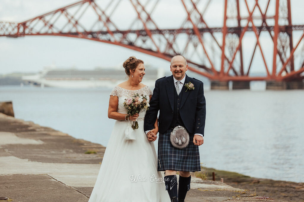 Beautiful Scottish Bride and Groom standing on Orroco Pier at South Queensferry. Photo Credit White Cherrie Photography. 