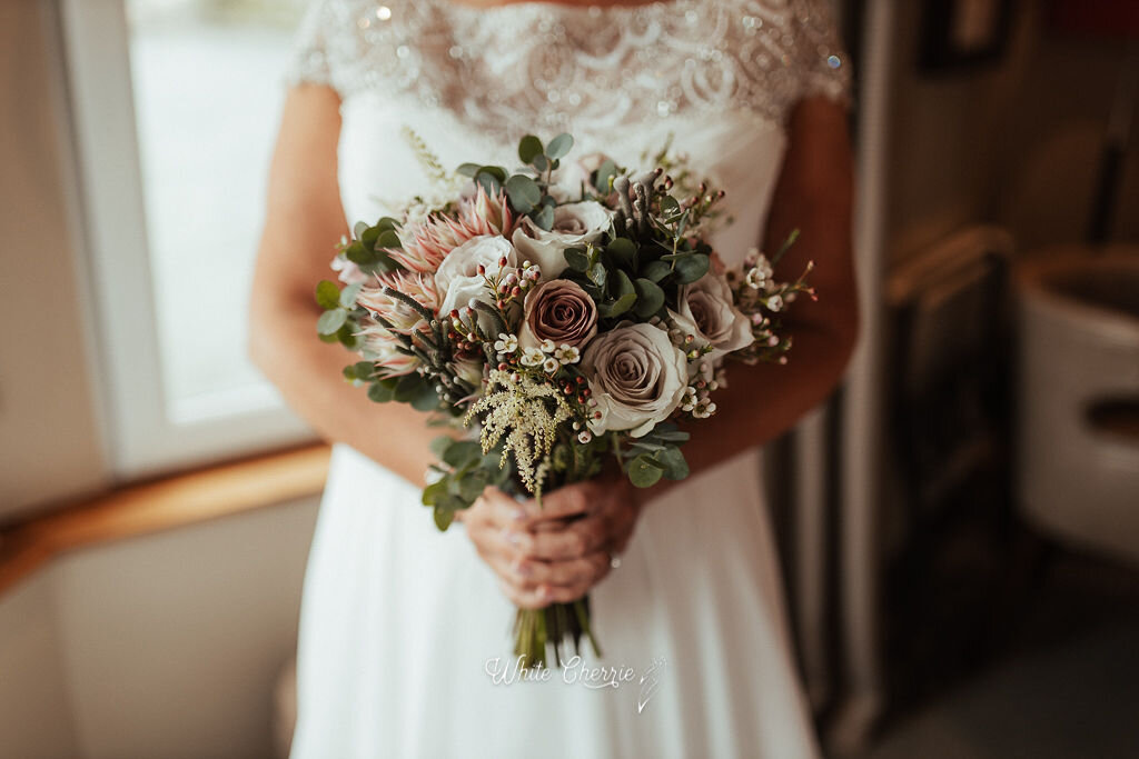 Scottish Bride holding her beautiful bridal bouquet by Stunning Flowers.