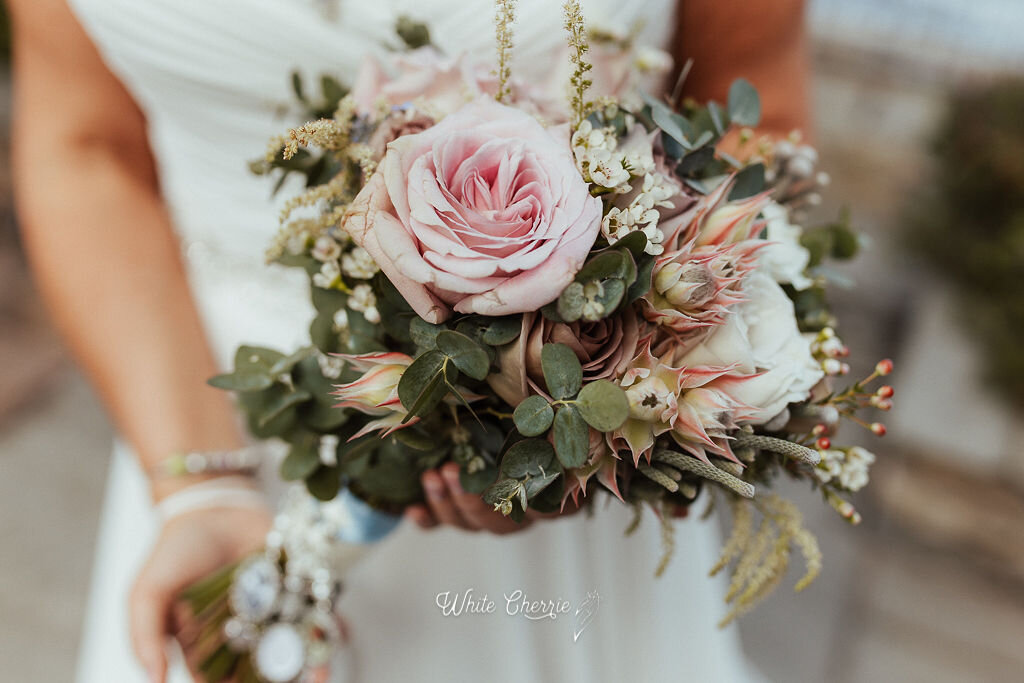 Scottish bride holding her wedding bouquet at Orrocco Pier. Photo by White Cherrie Photography. 