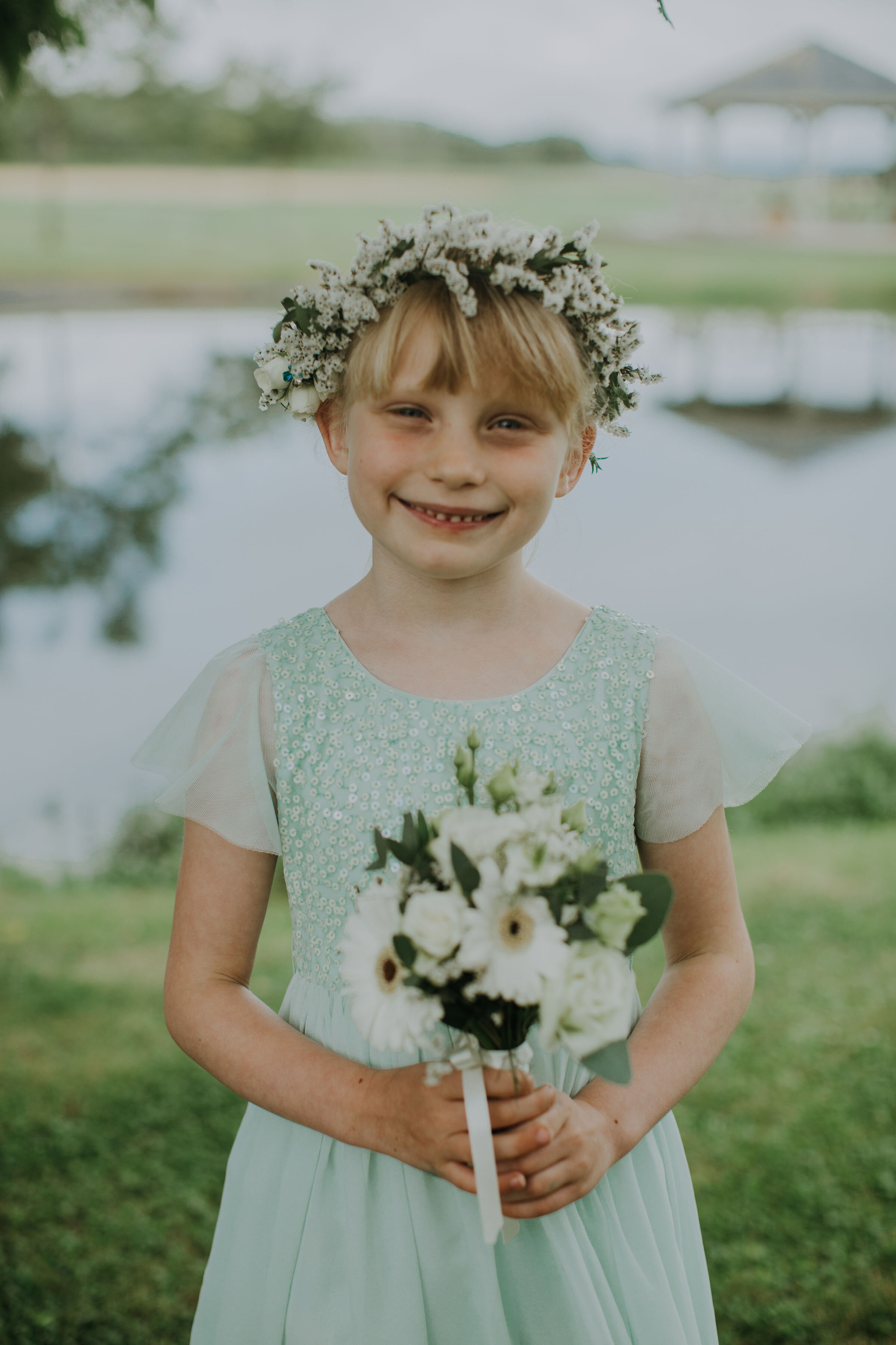 Scottish Flower girl holding wedding posy and wearing flower crown at Bachilton Barn, Scotland