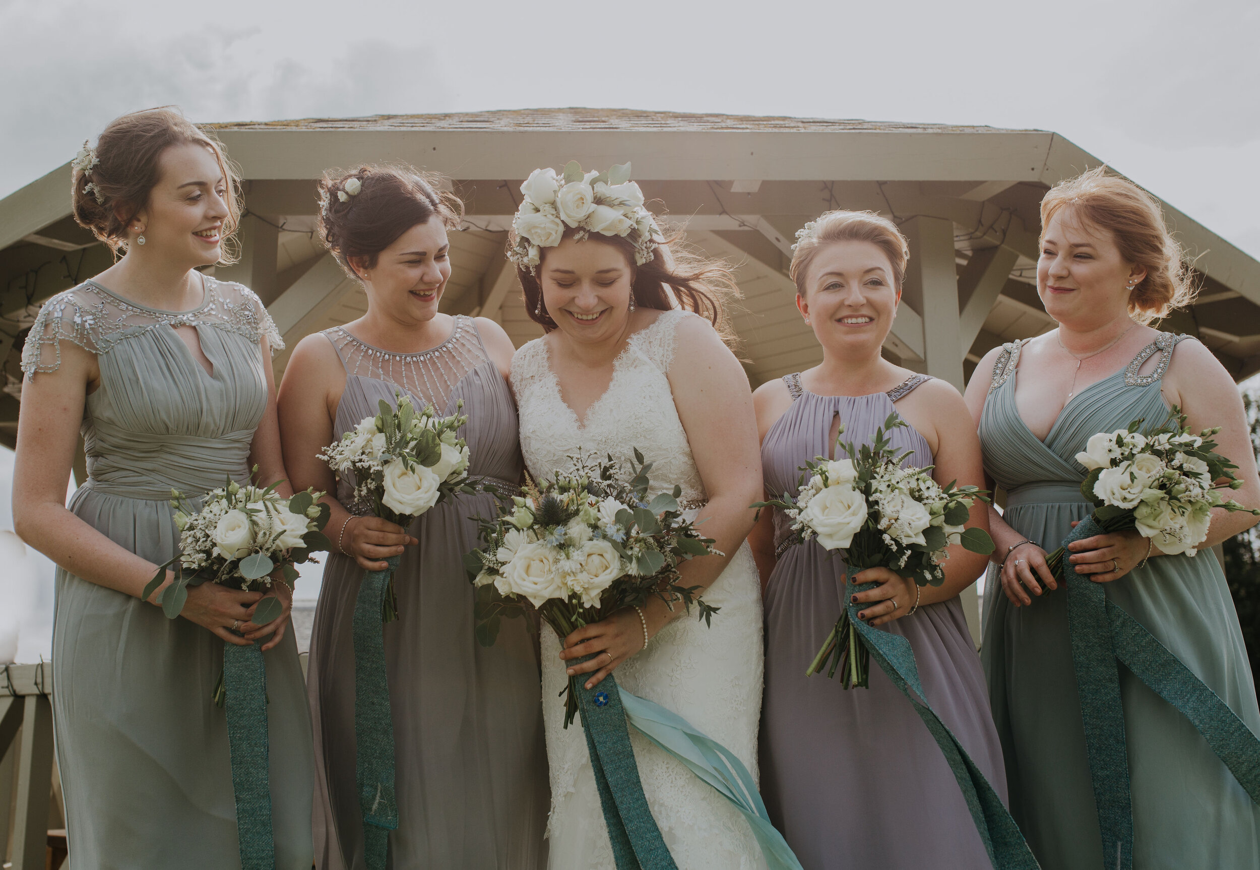 Scottish Bride and Bridesmaids laughing and holding wedding flowers at Bachilton Barn, Perthshire.
