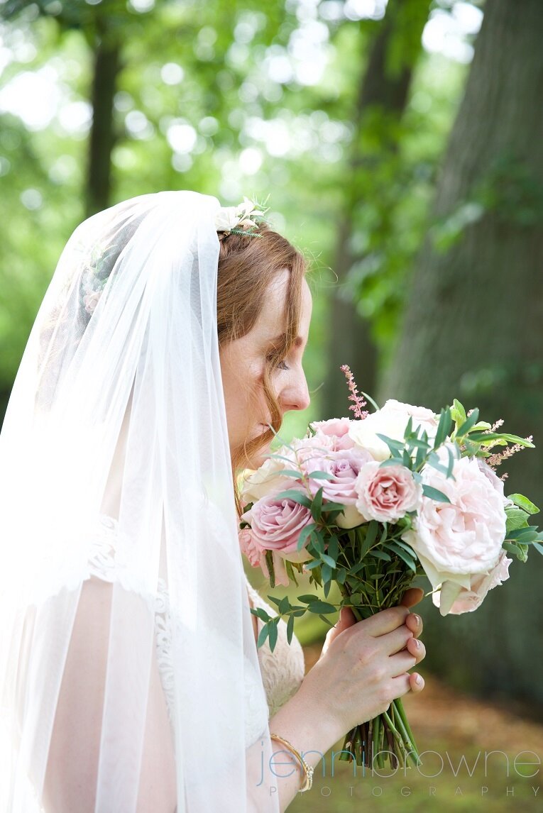Beautiful Scottish Bride smelling her pink and cream wedding bouquet at Murrayshall, Perthshire
