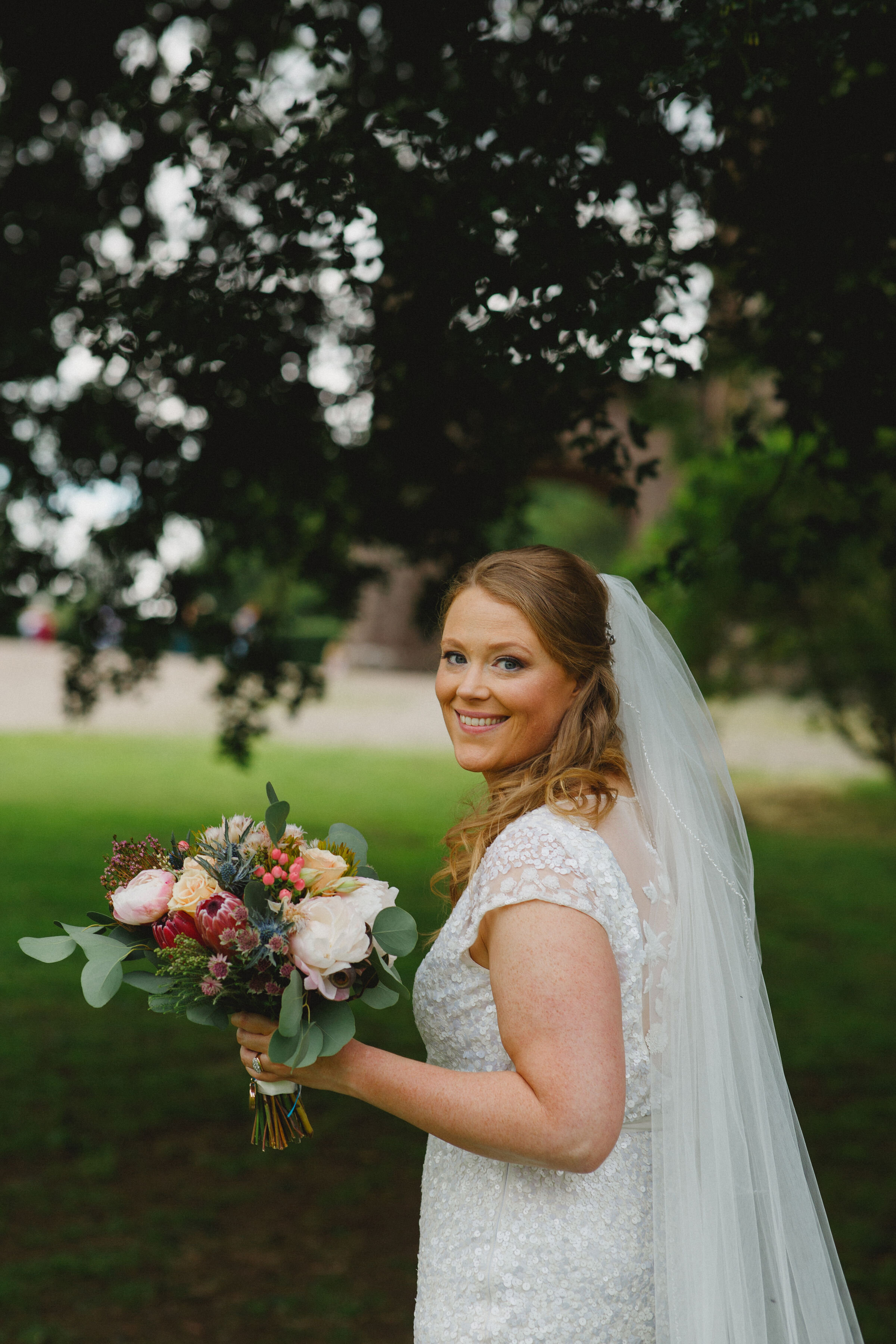 Bride holding wedding bouquet of mixed roses, peonies and eucalyptus at Strathallan, Scotland