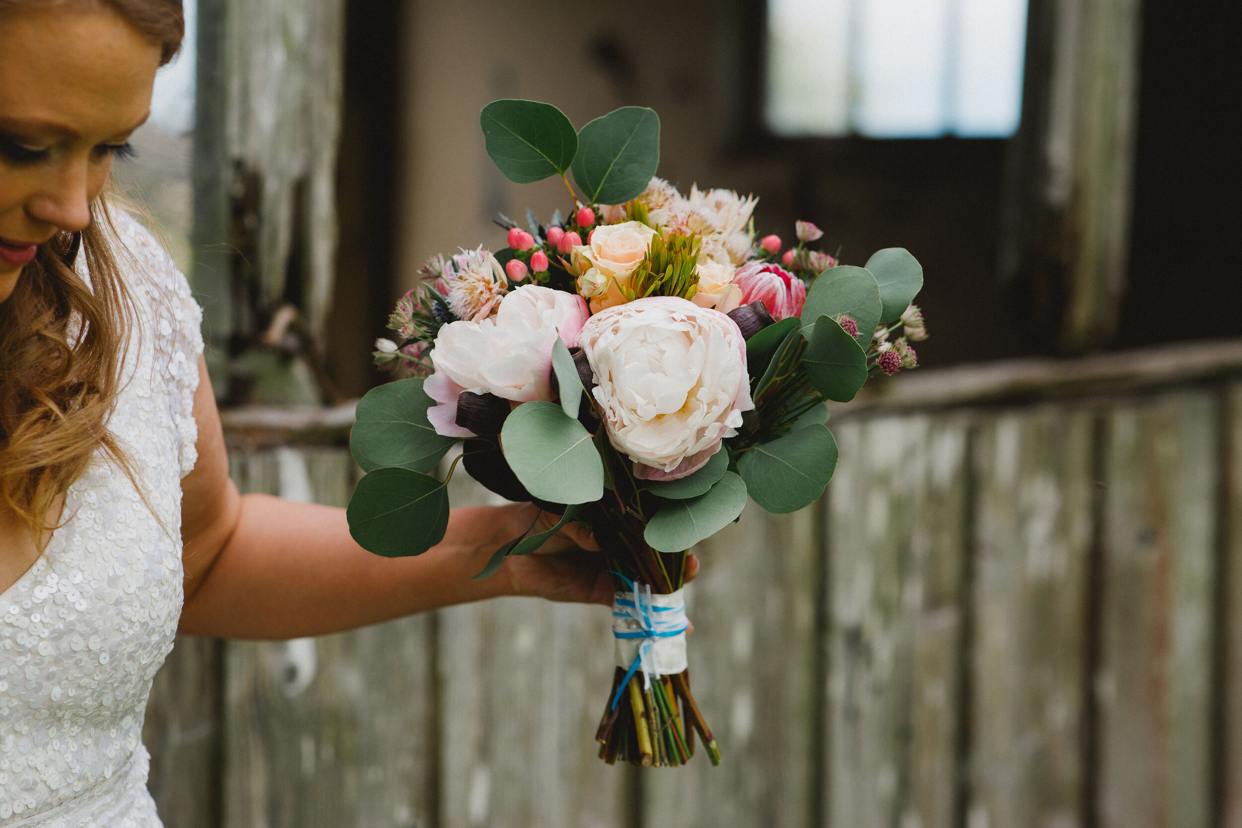 Bride holding Wedding bouquet of mixed roses, berrie, peony and eucalyptus 