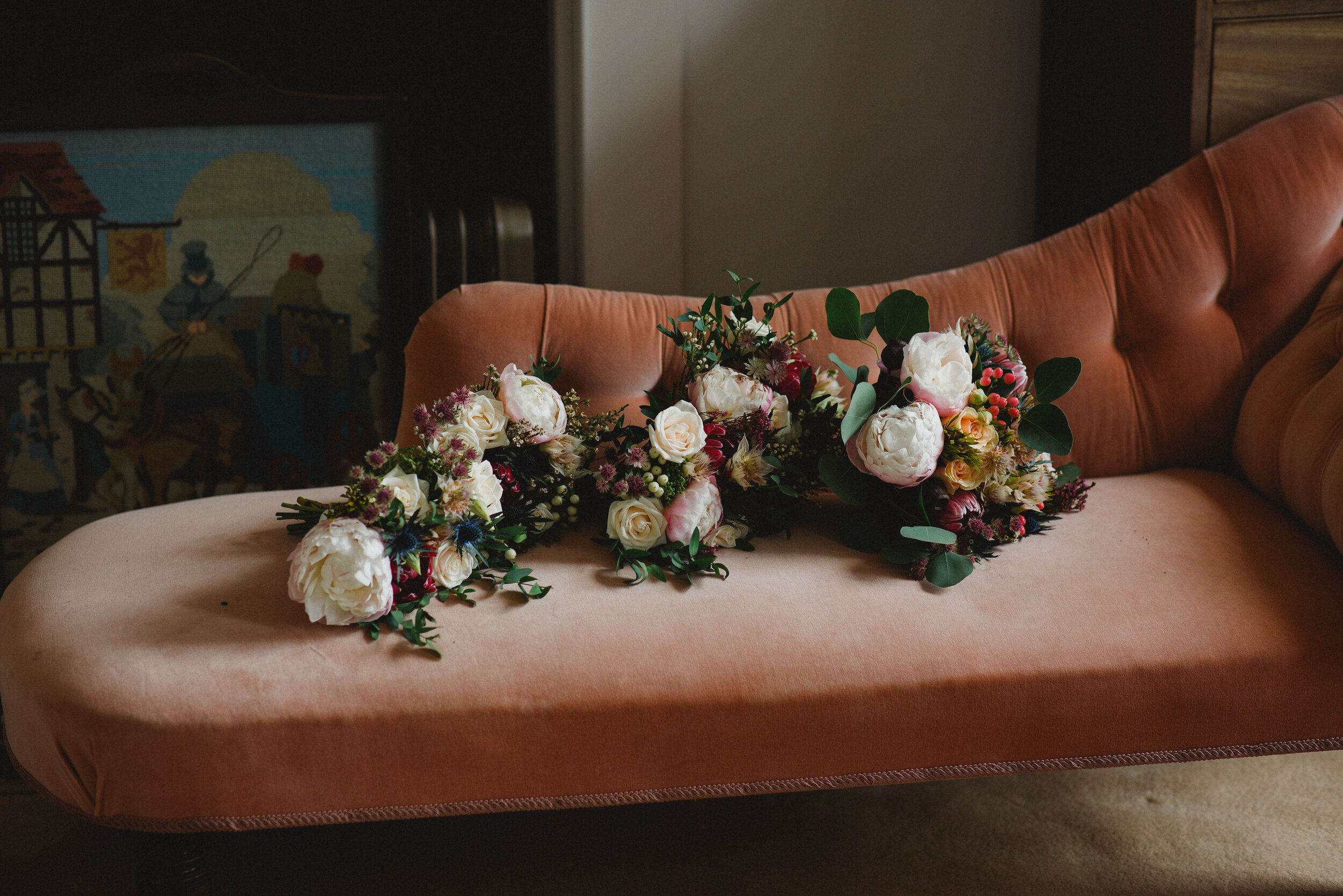 Stunning peonies and eucalyptus sitting on dusky pink chaise lounge 