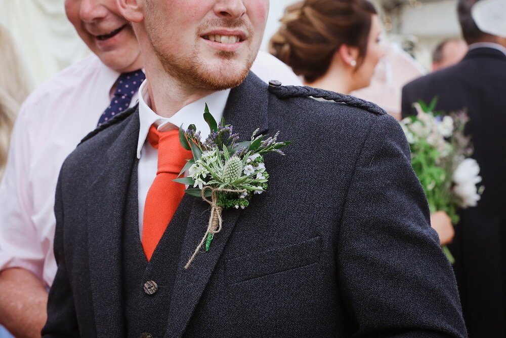 Groom wearing a buttonhole of Scottish thistle.