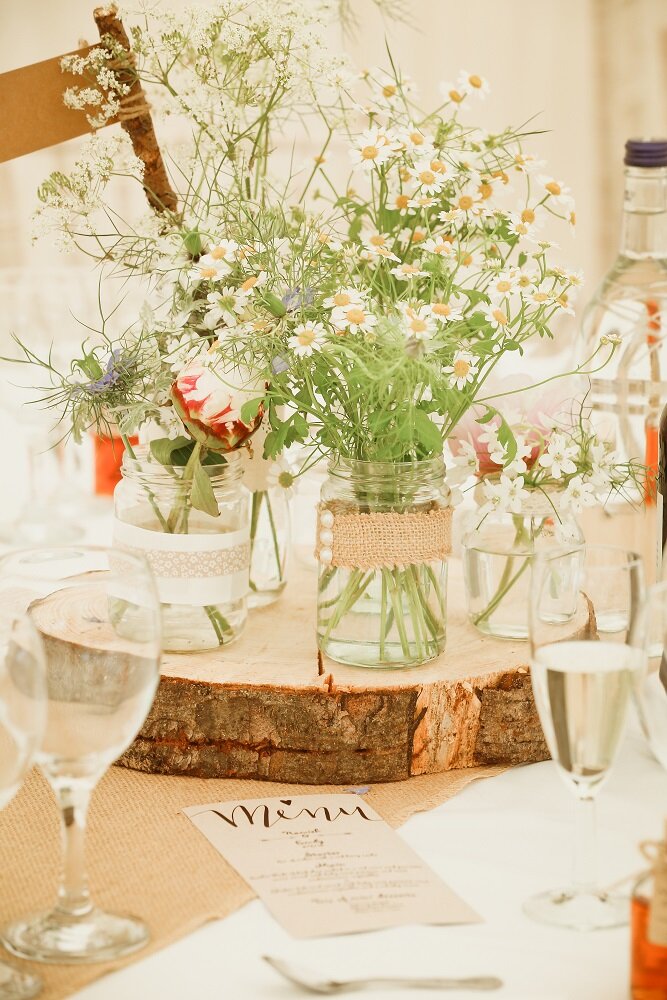 jam jars filled with daisies on wooden block at Perthshire wedding