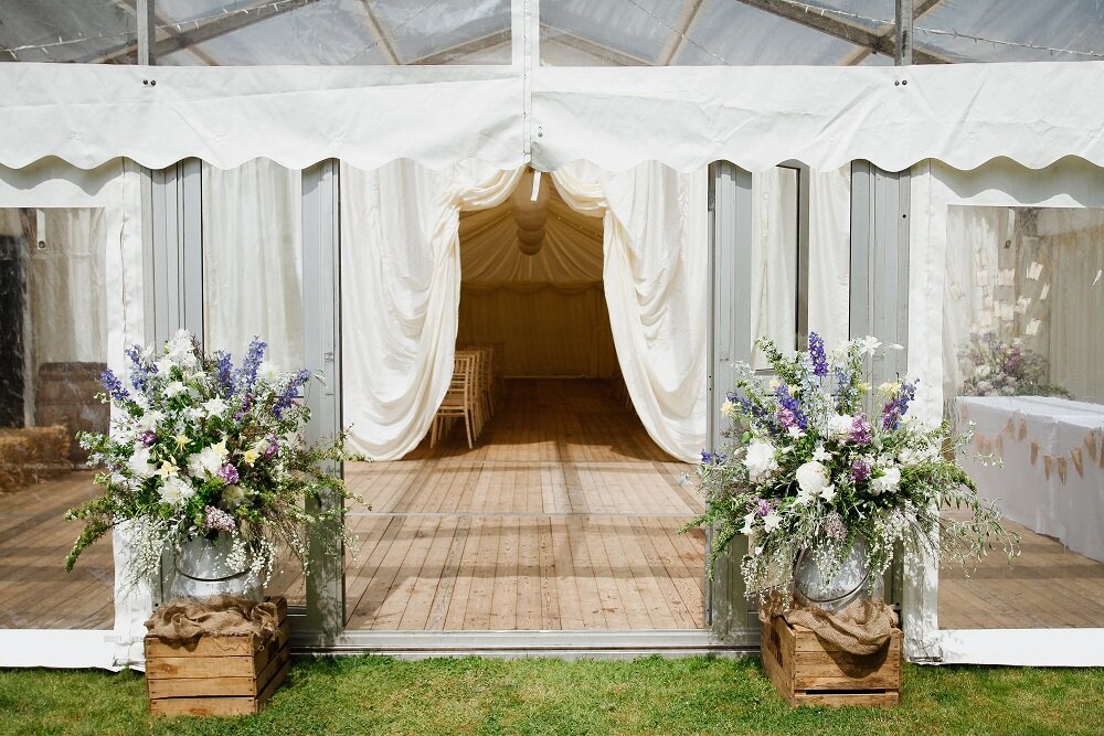 two large floral arrangements at the entrance to a marquee at a Perthshire wedding 