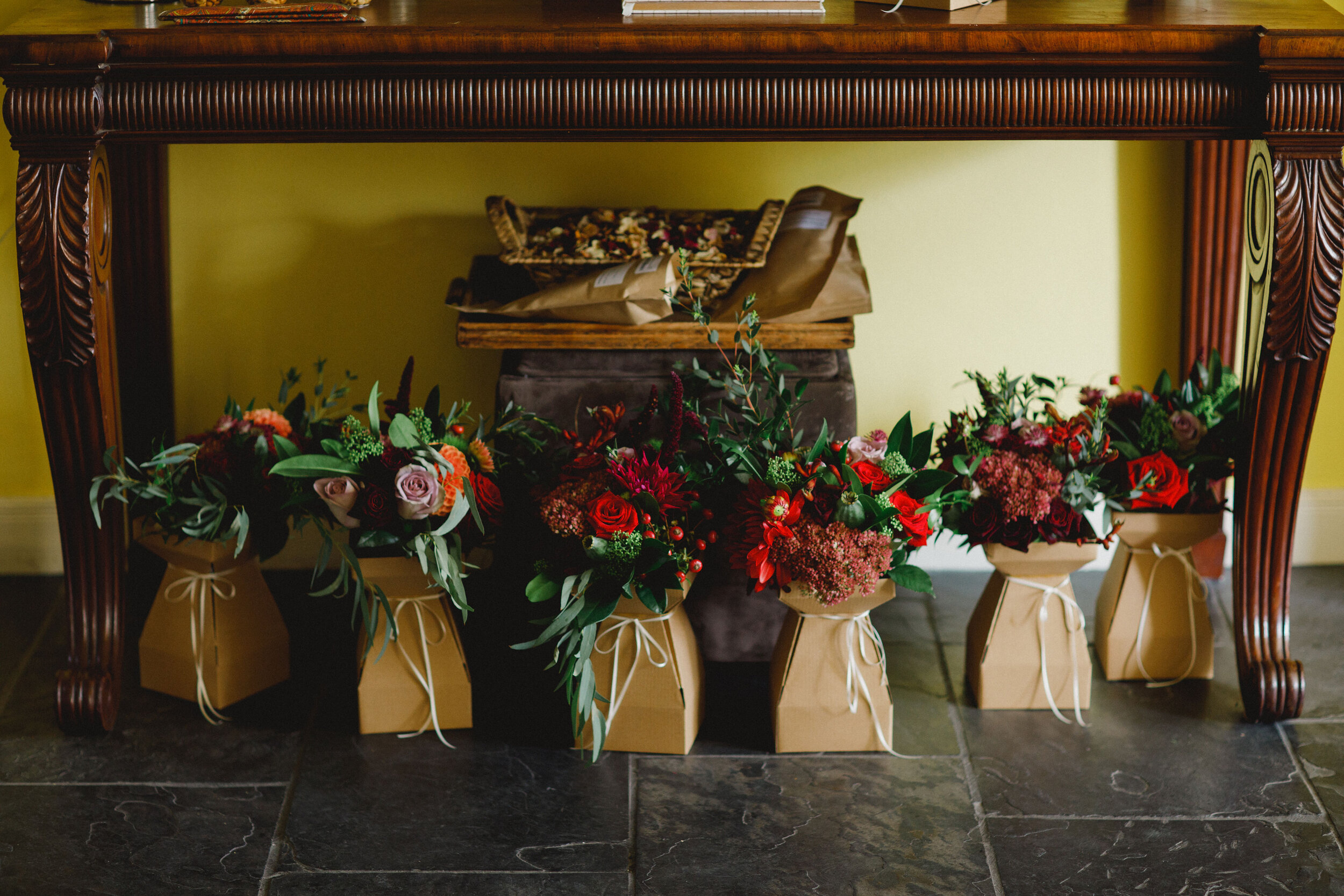 Green and red wedding bouquets round a fireplace 