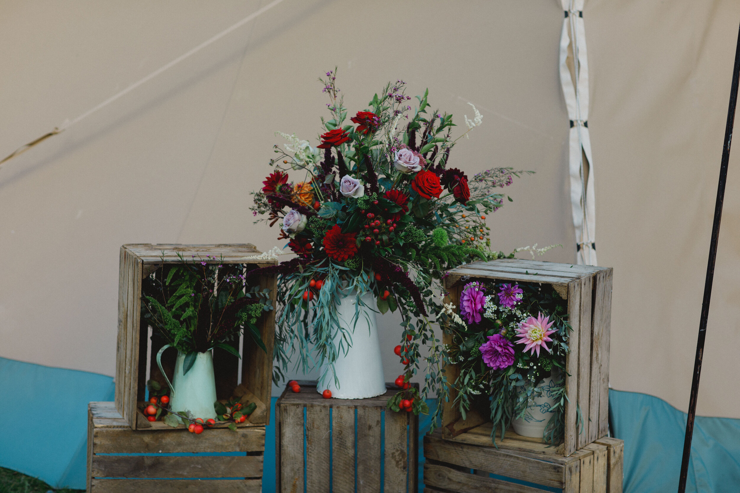 Wedding flower arrangement displayed in milk jugs and crates at Carphin House, St Andrews.