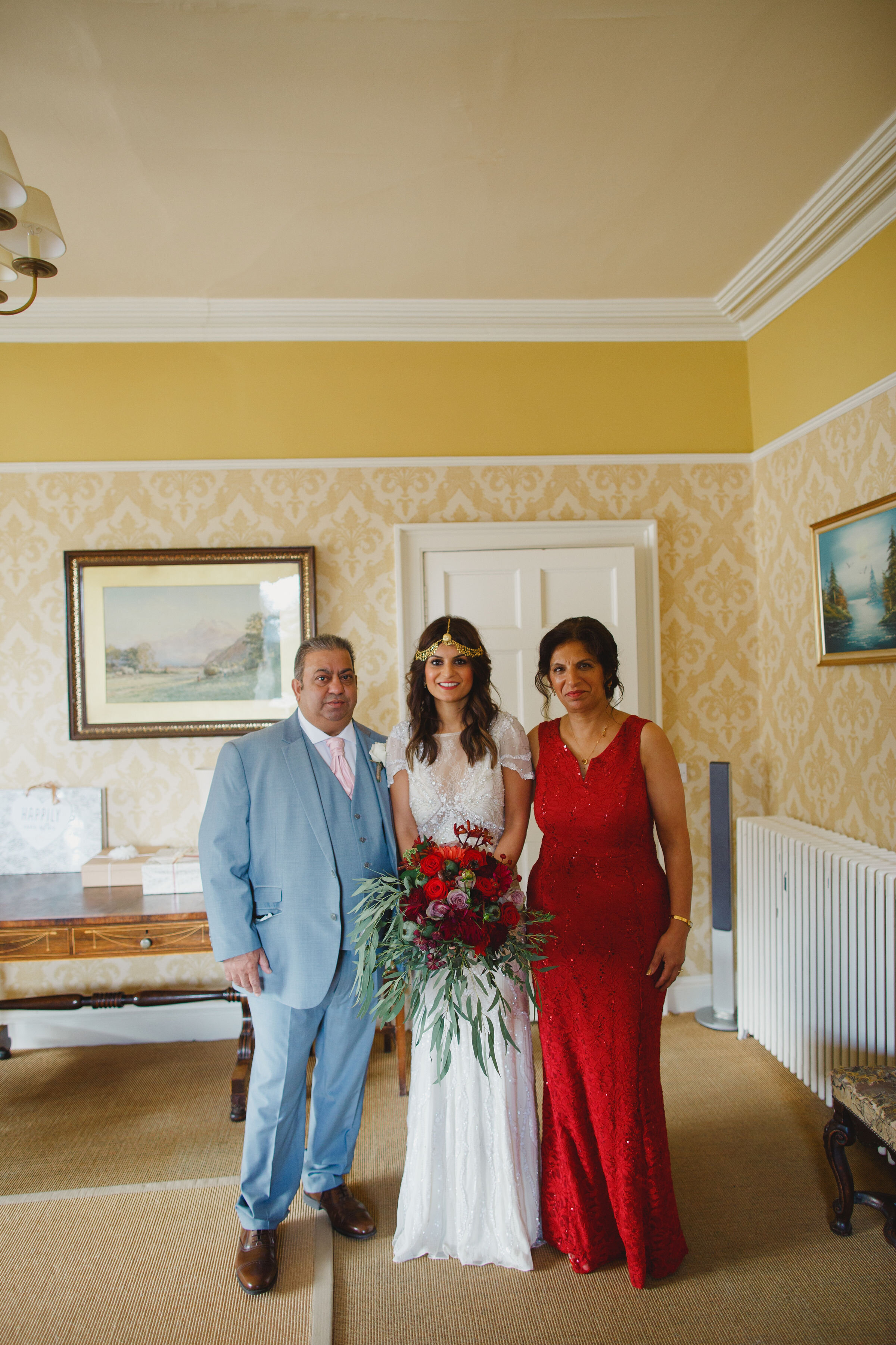 Bride standing with parents on wedding day at Carphin House, St Andrews. 
