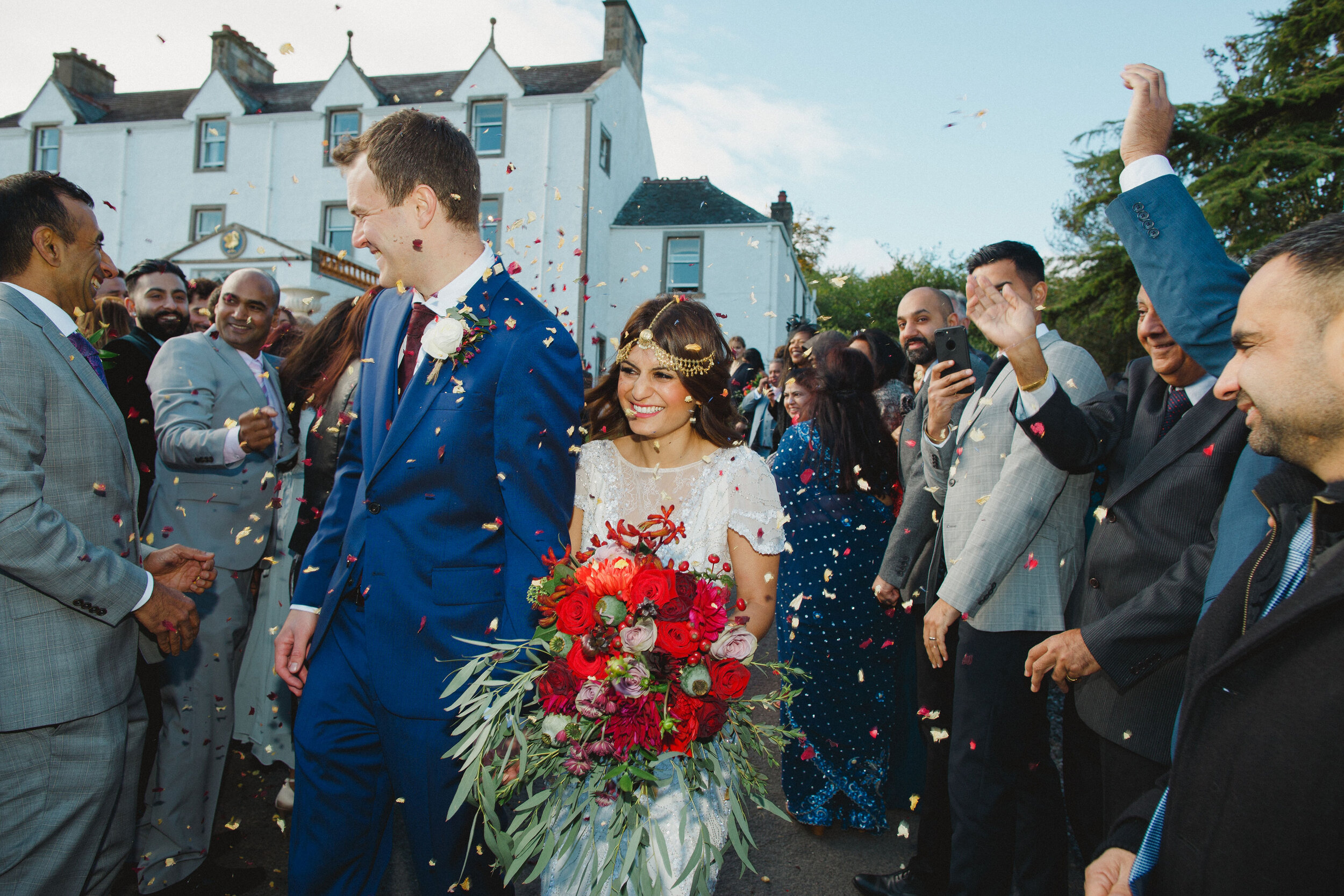 Bride and Groom being showered with confetti in the grounds of Carphin House, St Andrews