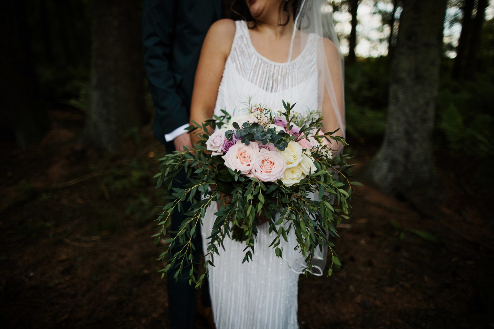 Bride standing in the forest holding bridal bouquet full of Eucalyptus 