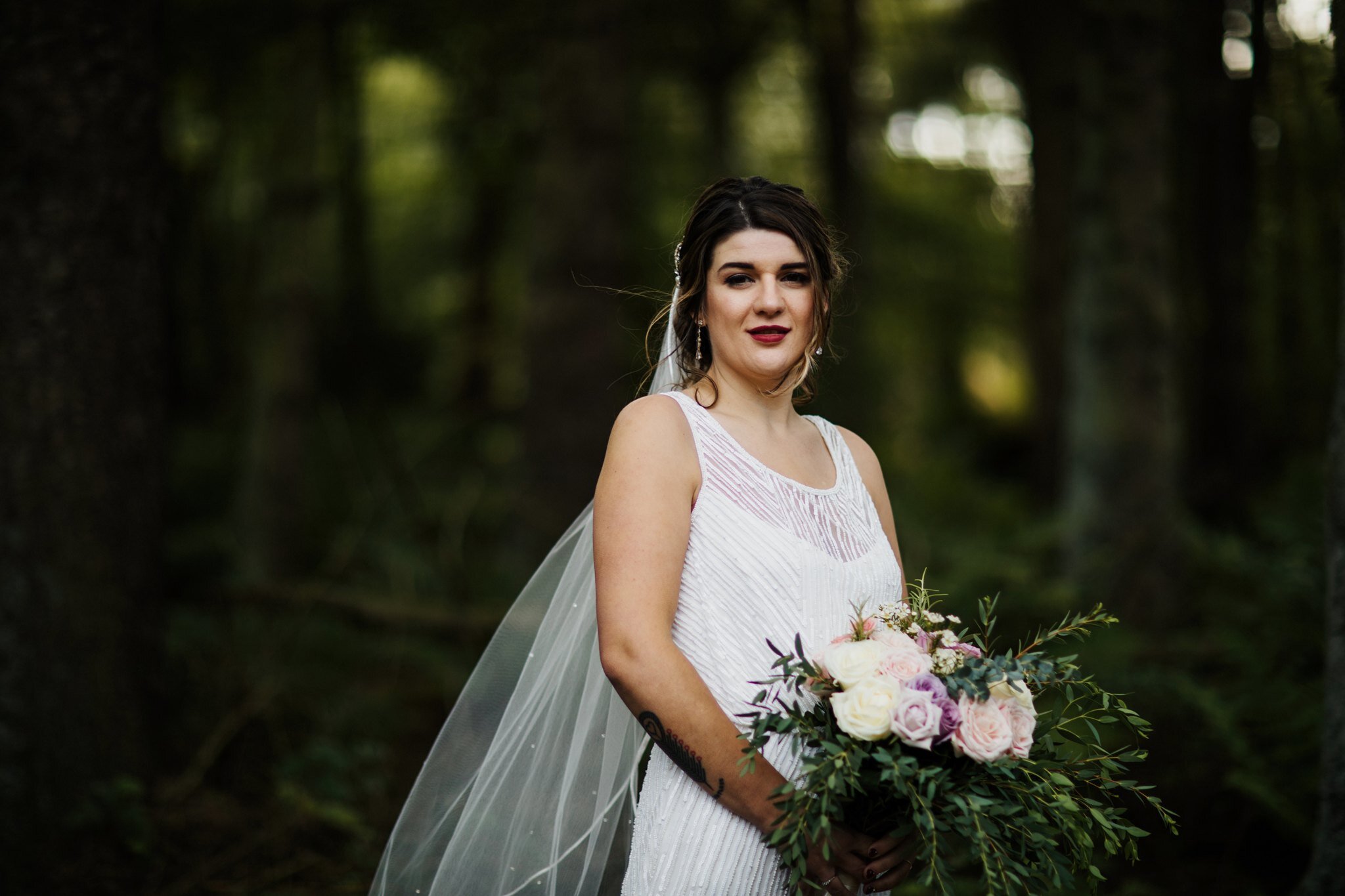 Scottish bride holding bouquet in the forest