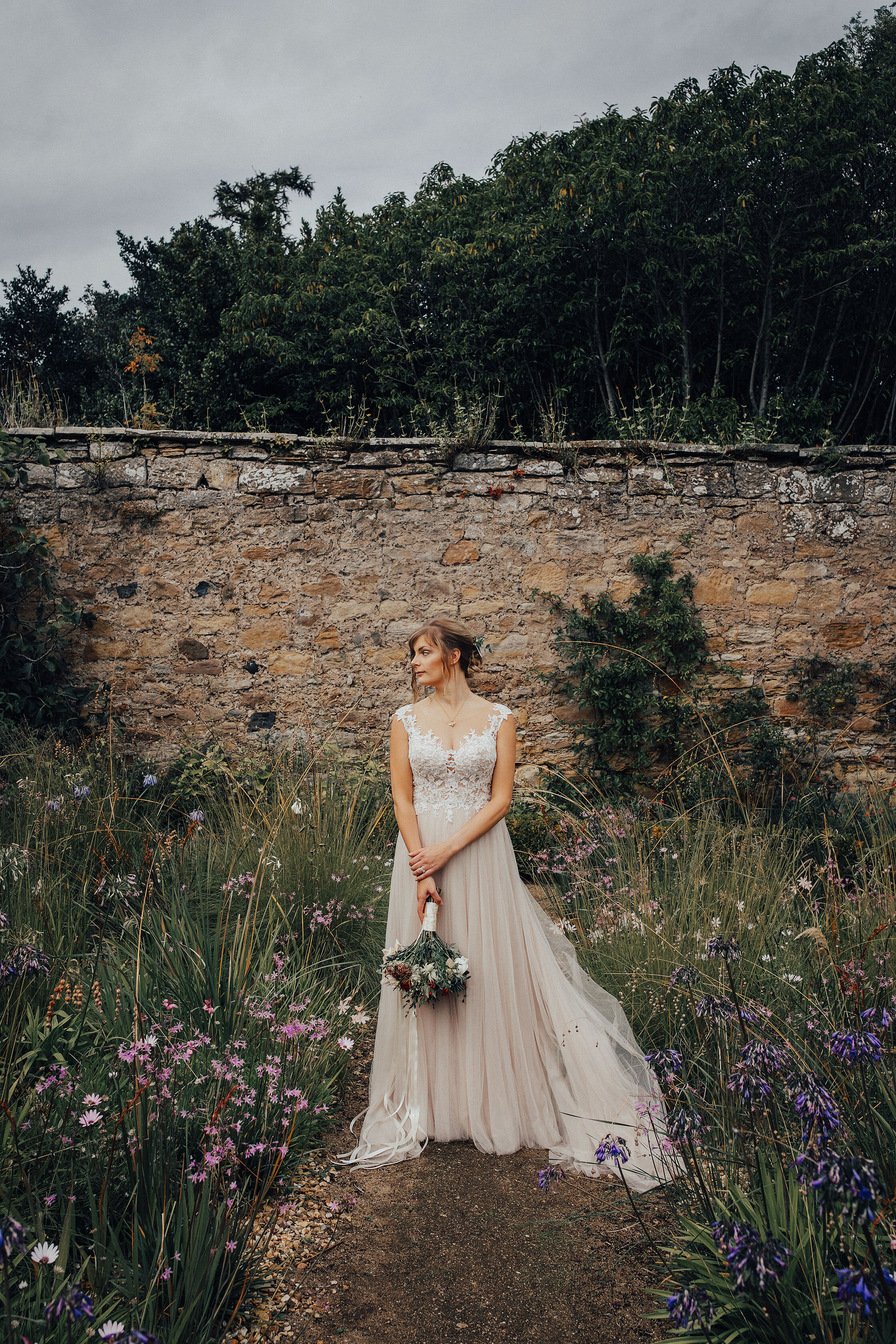 Brides in dusky pink gown standing in walled garden at Cambo Estate, St Andrews