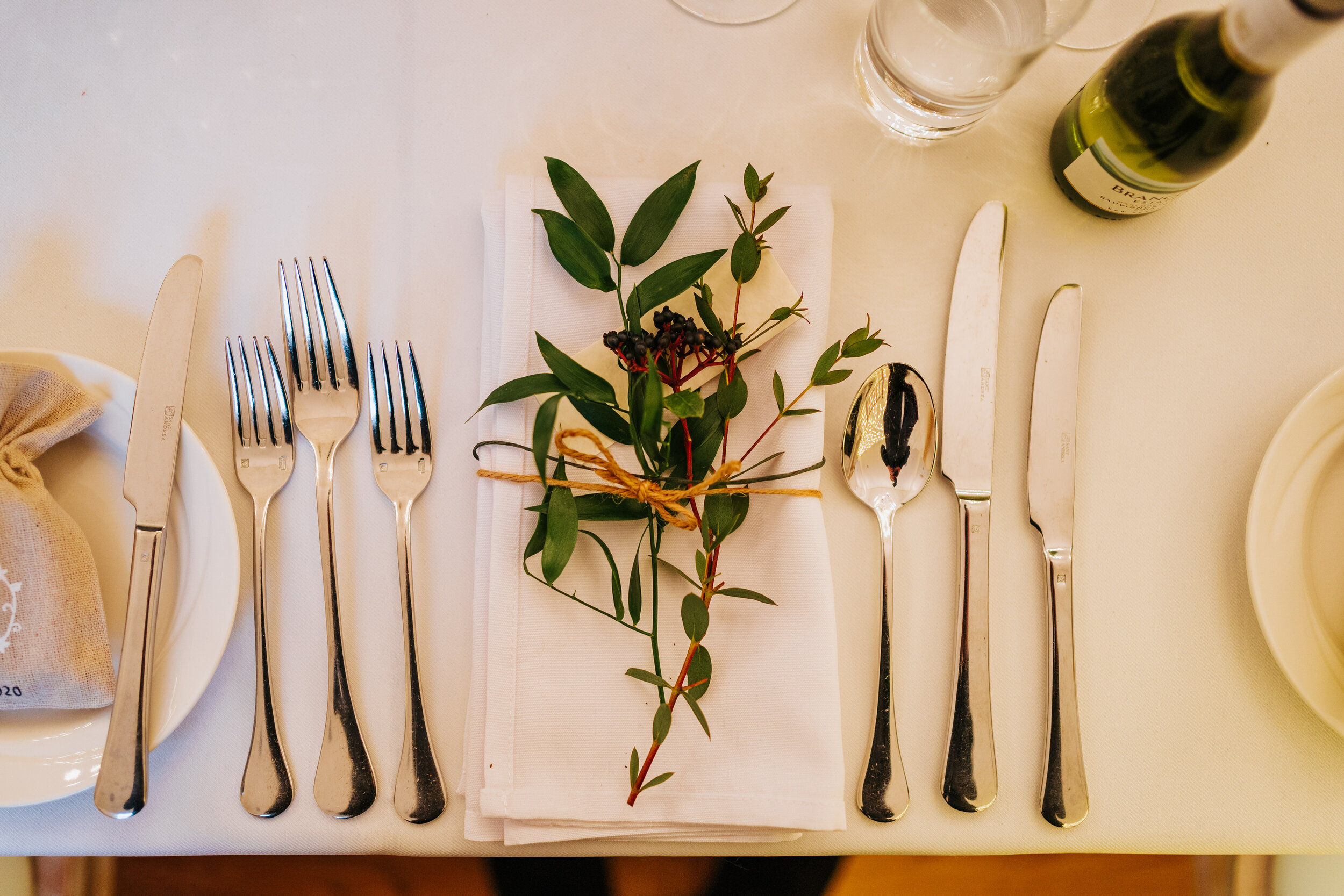 Table setting at Newhall estate with white napkin and sprig of greenery