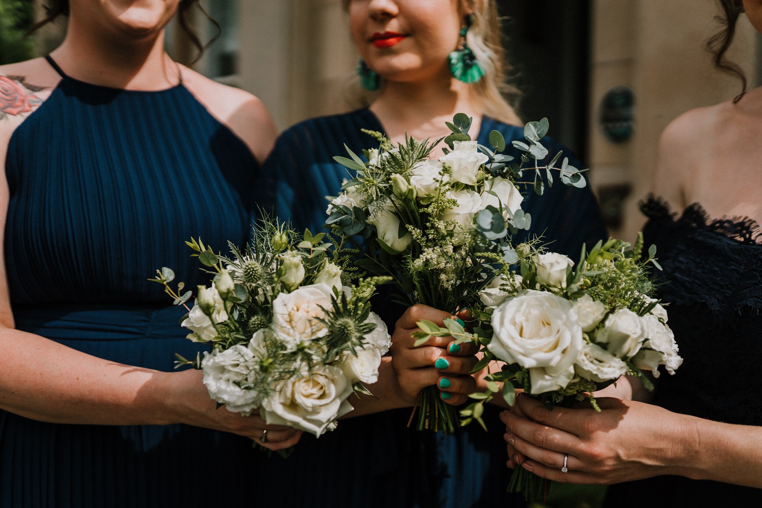 Bridesmaids dressed in Navy gowns holding wedding flowers at Bachilton Barn, Perthshire